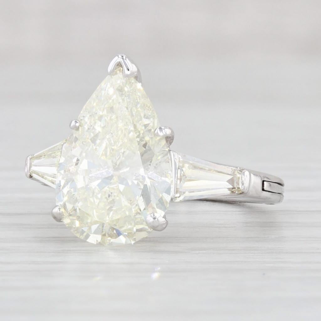 Gemstone Information: Natural Diamonds - 4.99 Total Carats
- Solitaire -
Carats - 4.24ct (13.9 x 9.3 mm) 
Cut - Pear Brilliant
Color - N
Clarity - I1 
GIA: 6224735783

- Accents -
Total Carats - 0.75ctw 
Cut - Baguette
Color - O - P
Clarity - VS2 -