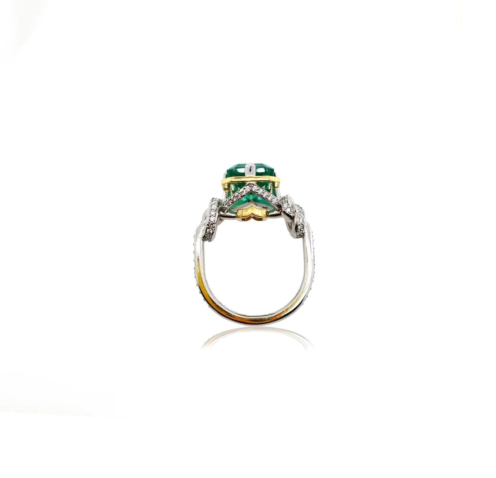 Glamorously bold and unabashedly seductive. This showstopper ring features an intense natural emerald cut Emerald poised between sharp eagle style talons and embraced by powerful-platinum, diamond encrusted ropes, converging to two knots on either