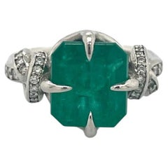 4ct Emerald solitaire in platinum with diamond knots 