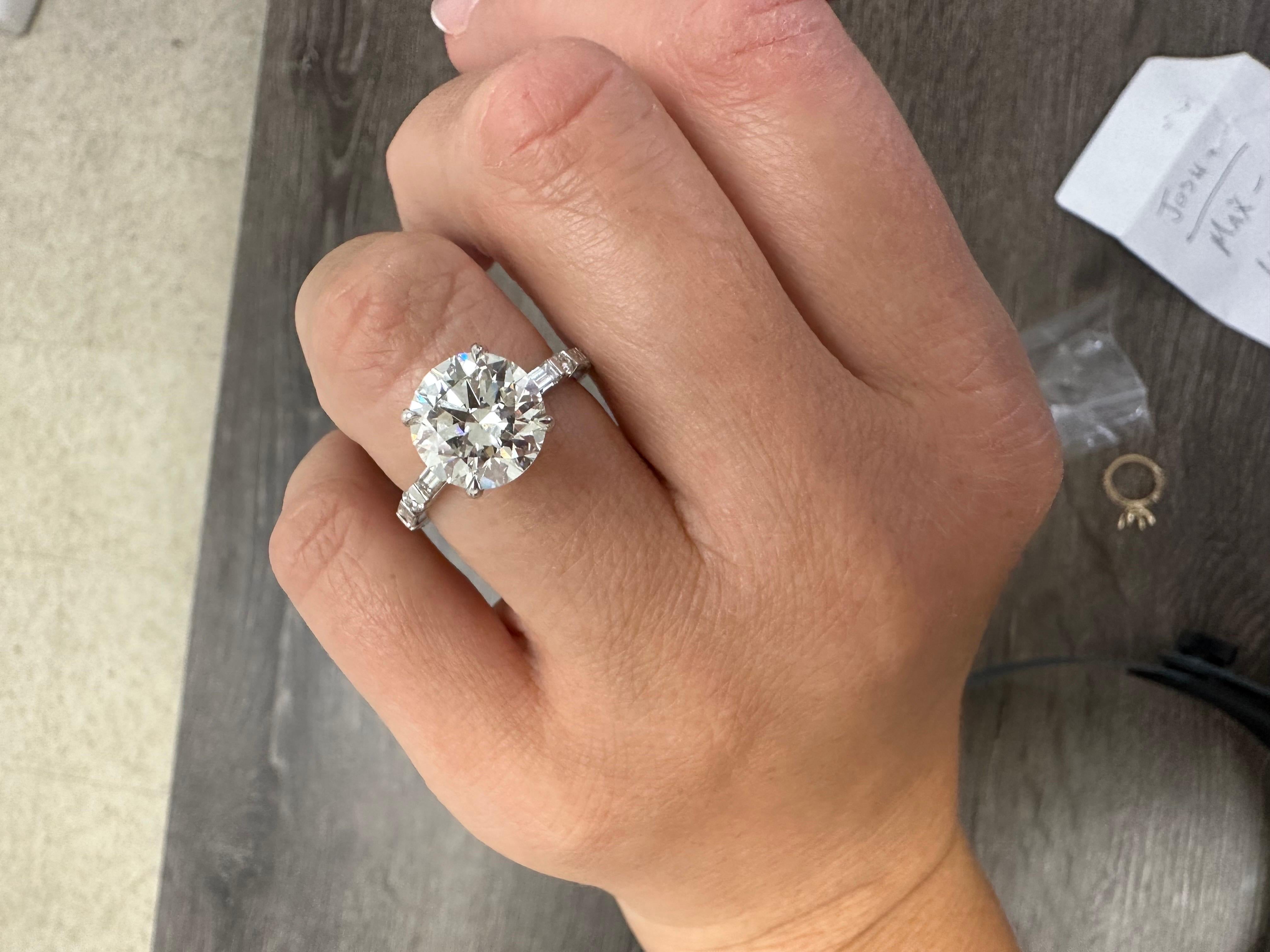 Stunning 4 carats moissanite center surrounded by natural diamond on the shank set half way down. The ringf is made in 18KT gold and is a size 6. The ring can be re-sized. Diamonds are Si clarity and G color, moissanite is VVS1 clarity and F