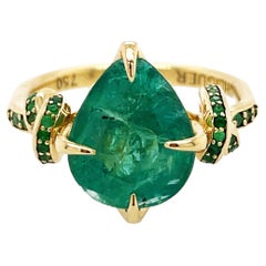 4ct pear cut emerald solitaire with emeralds in 18ct yellow gold