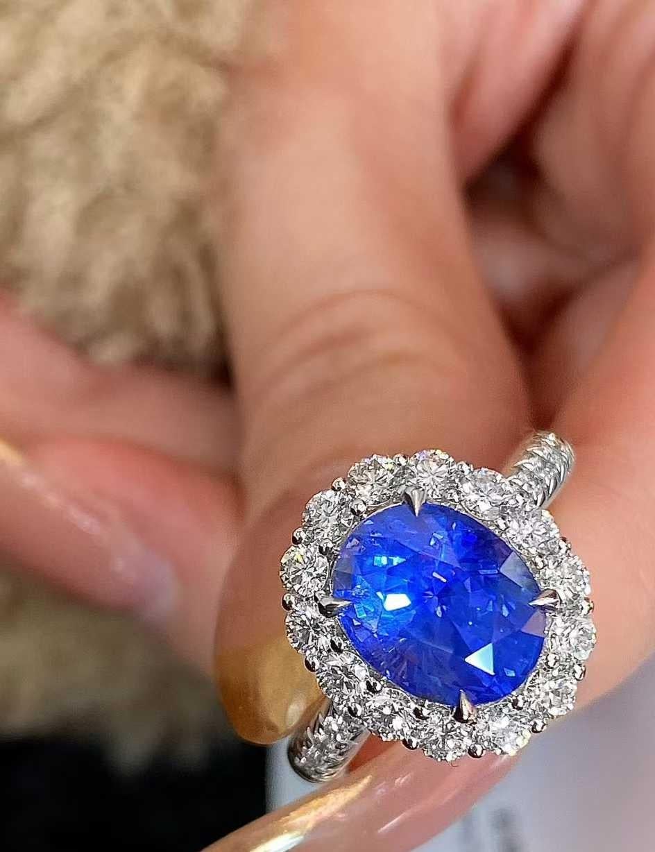 Dieser exquisite 4-karätige Saphirring ist ein wahrer Blickfang, der von einem Halo aus runden weißen Diamanten von 0,80 Karat hervorgehoben wird, die alle in strahlendes 18-karätiges Weißgold gefasst sind. Der leuchtend blaue Saphir mit seiner