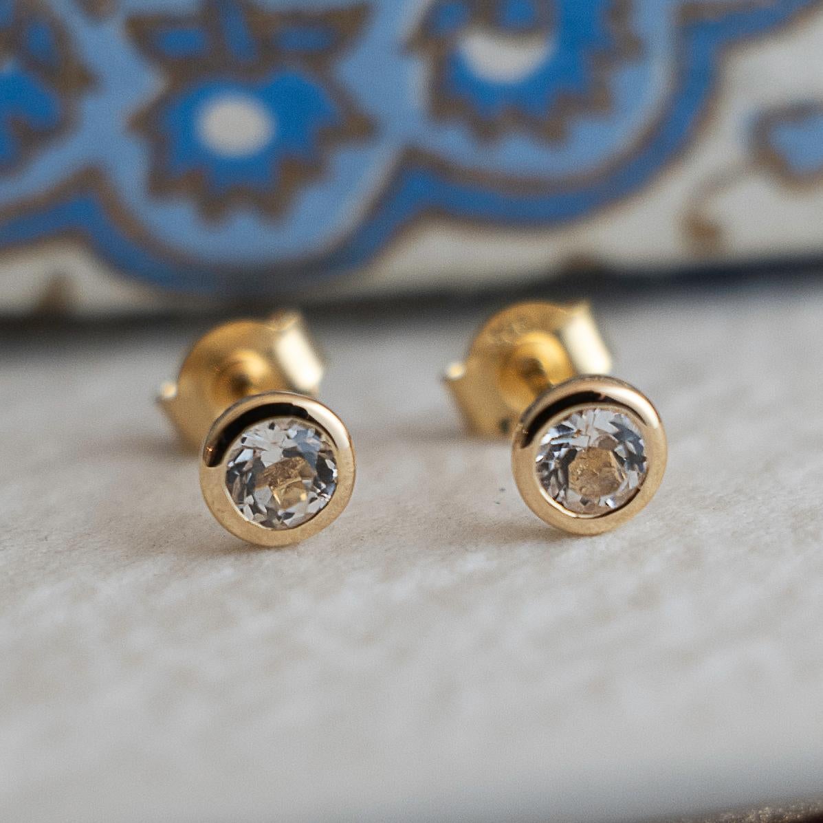 Round Cut 4mm White Topaz Gold Plated Sterling Silver Stud Earrings For Sale