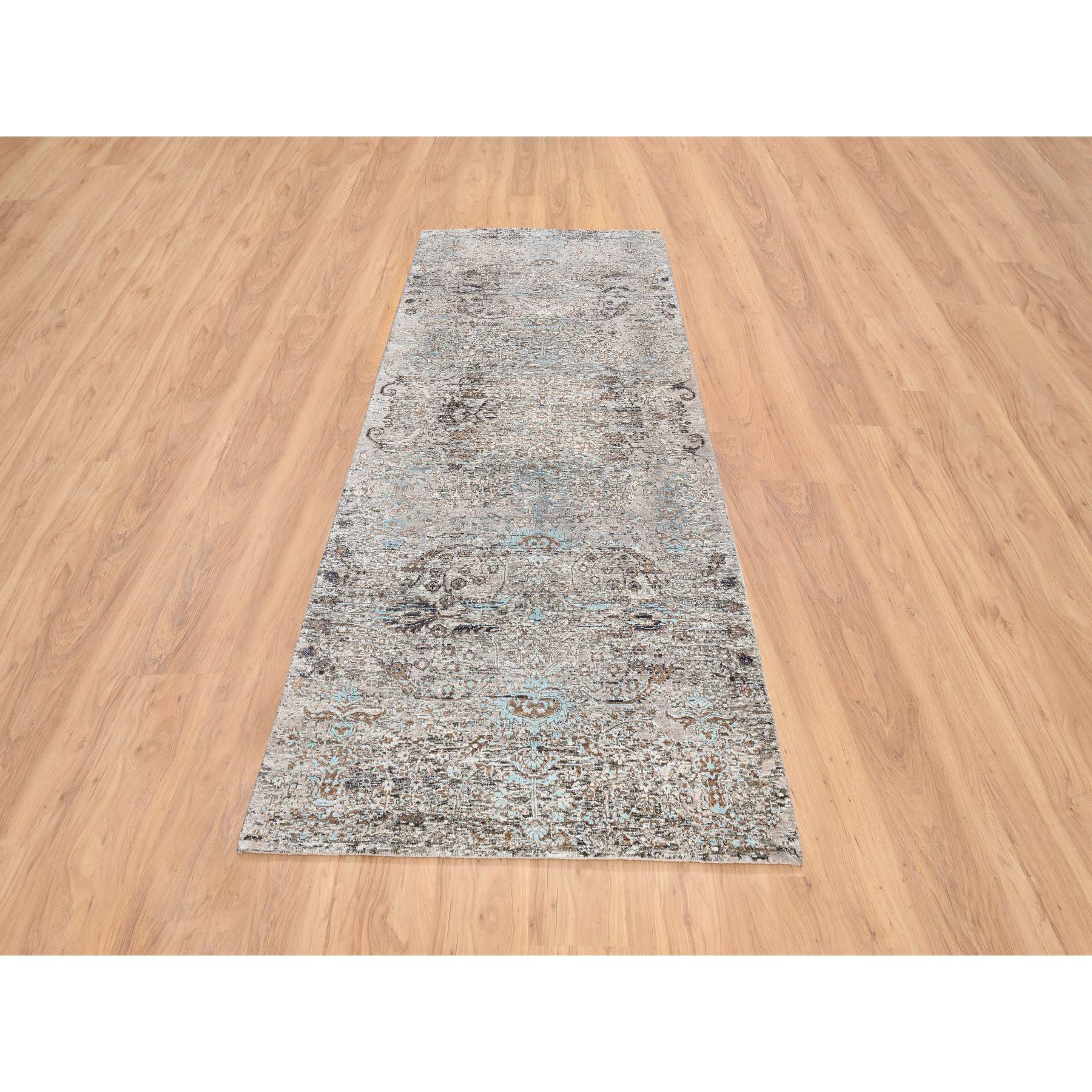 Il s'agit d'un véritable tapis d'Orient gris, d'influence persane transitionnelle, à motifs de médaillons effacés, en soie et laine texturée, noué à la main, à large couloir. Il a été noué pendant des mois et des mois dans le cadre d'un tissage