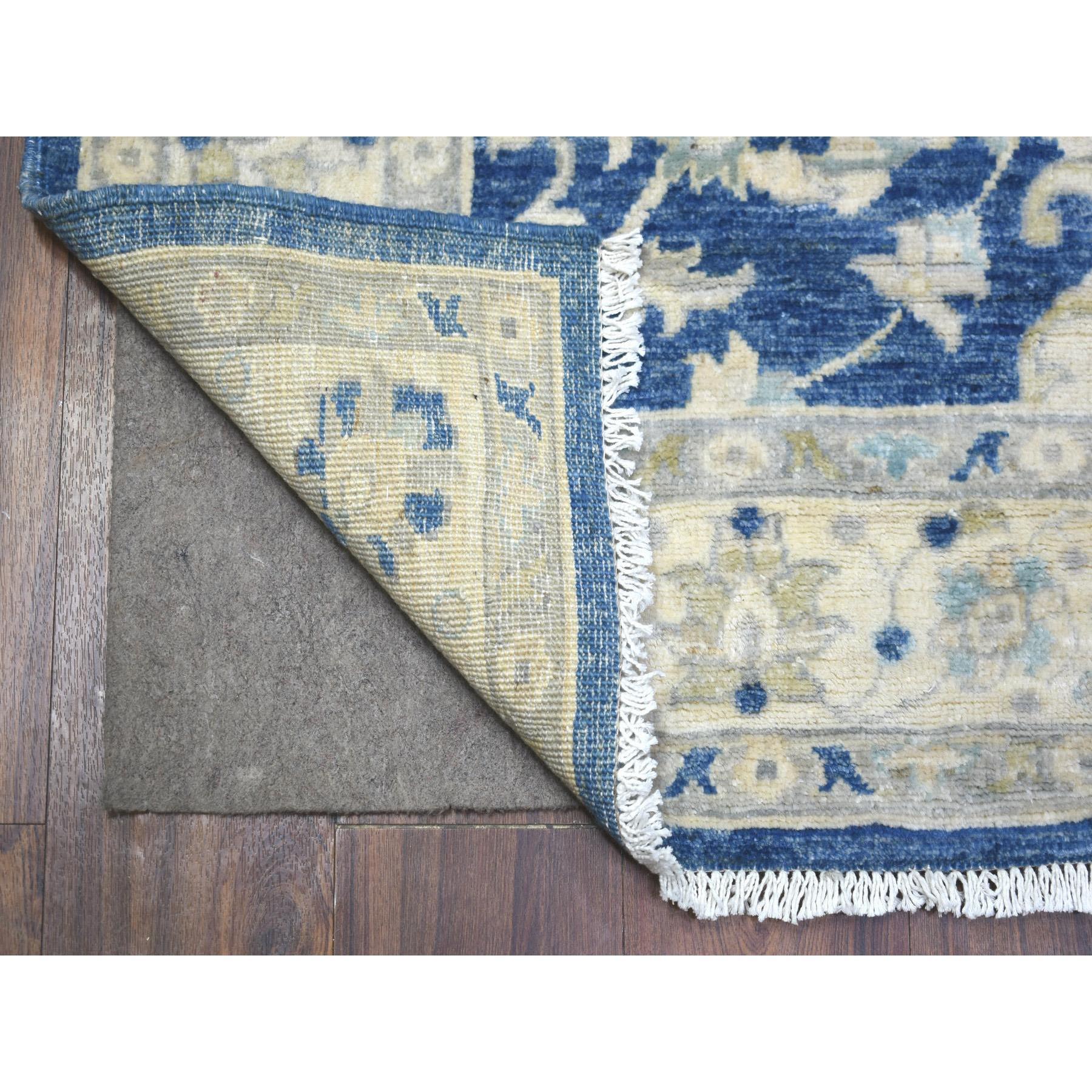 Il s'agit d'un véritable tapis d'Orient, unique en son genre, de couleur bleu denim, noué à la main à Peshawar avec des motifs floraux, densément tissé en laine organique, avec un large chemin de roulement. Il a été noué pendant des mois et des mois