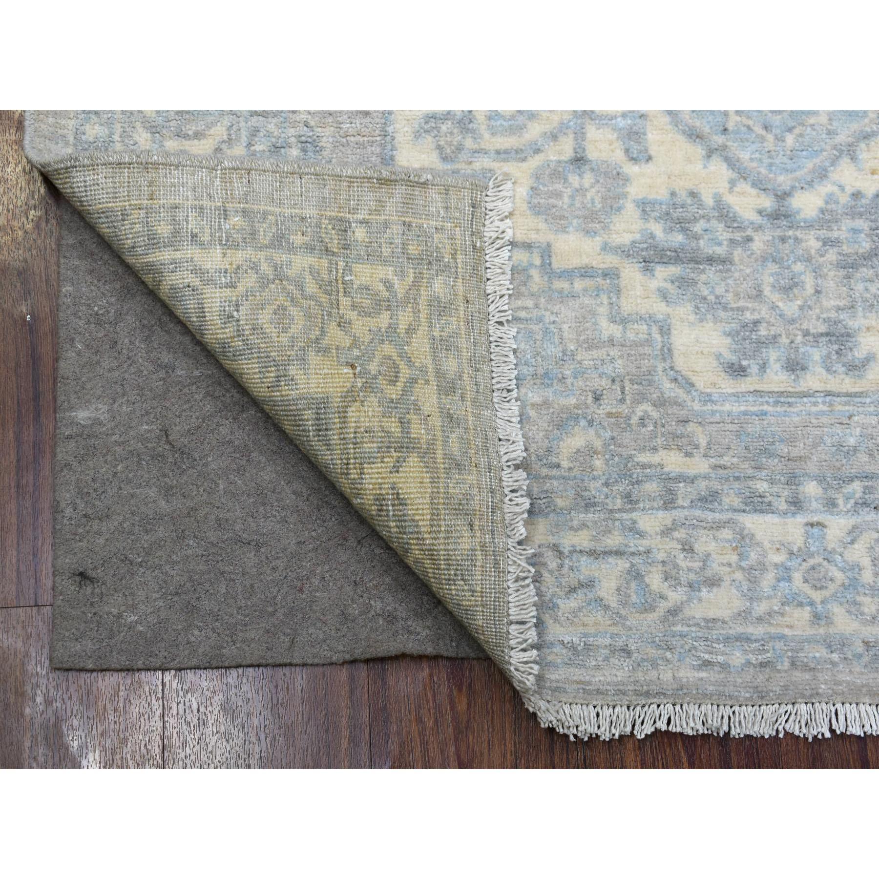 Il s'agit d'un véritable tapis d'Orient en laine afghane beige Stone Wash Peshawar à motifs de médaillons géométriques, noué à la main. Il a été noué pendant des mois et des mois selon des techniques de tissage séculaires par des artisans