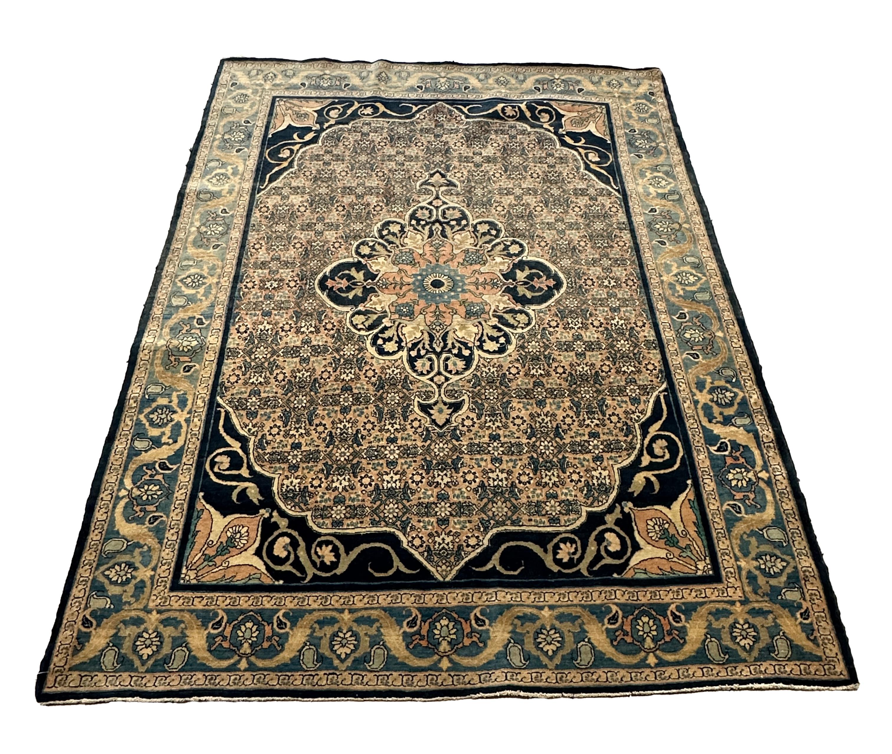 Wir stellen Ihnen unseren beigen und blauen Perserteppich Old 4.7x6.2 vor, ein atemberaubendes Beispiel traditioneller persischer Kunstfertigkeit mit zeitlosem Reiz. Dieser elegante Teppich zeichnet sich durch einen raffinierten beigen Hintergrund