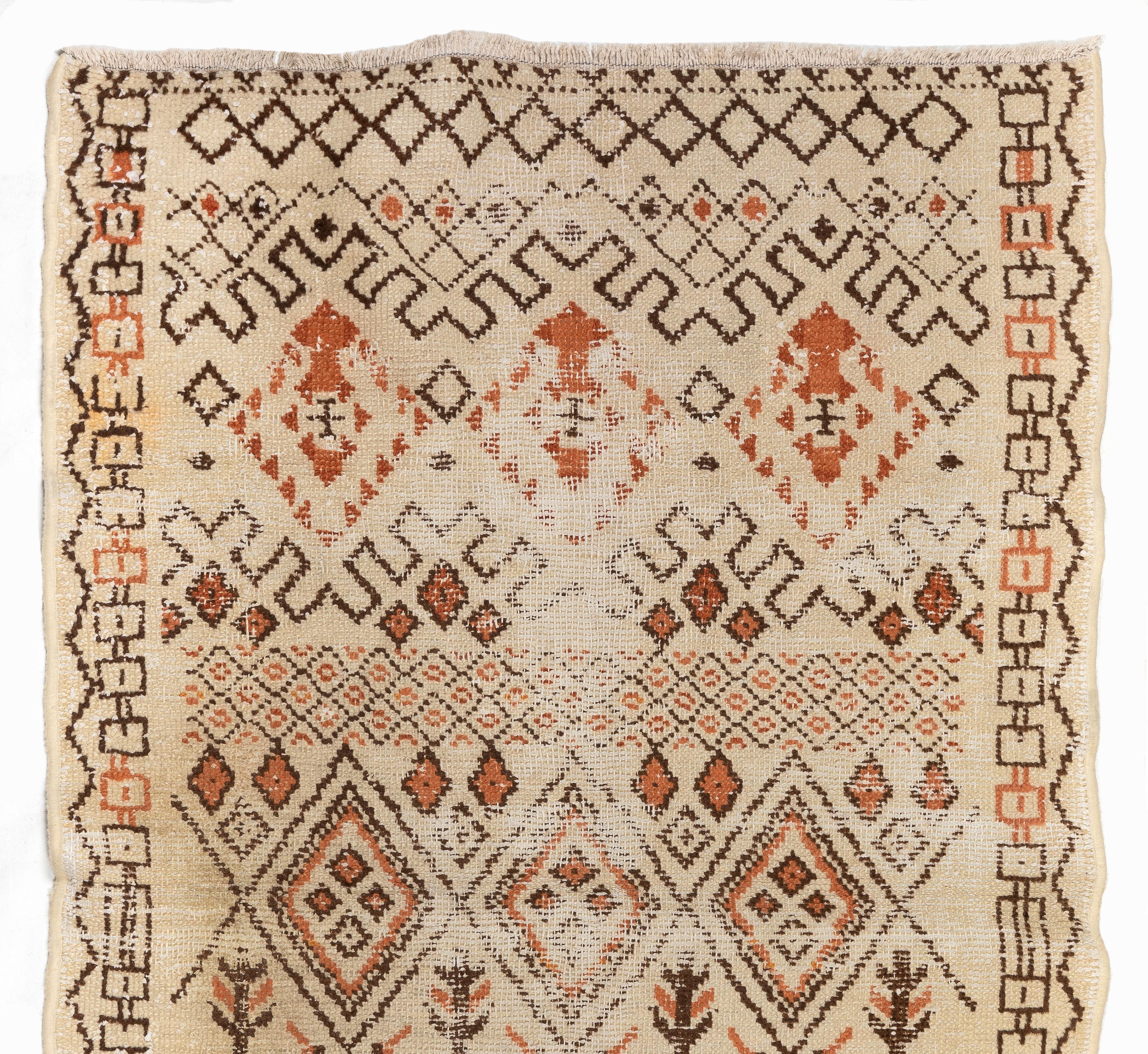 An antique Turkish tribal rug with a unique, whimsical design of bold geometric motifs in soft earthy colors of cream, rust orange and brown. The field is divided into three areas, each of which is decorated with its own distinct diamond shapes and