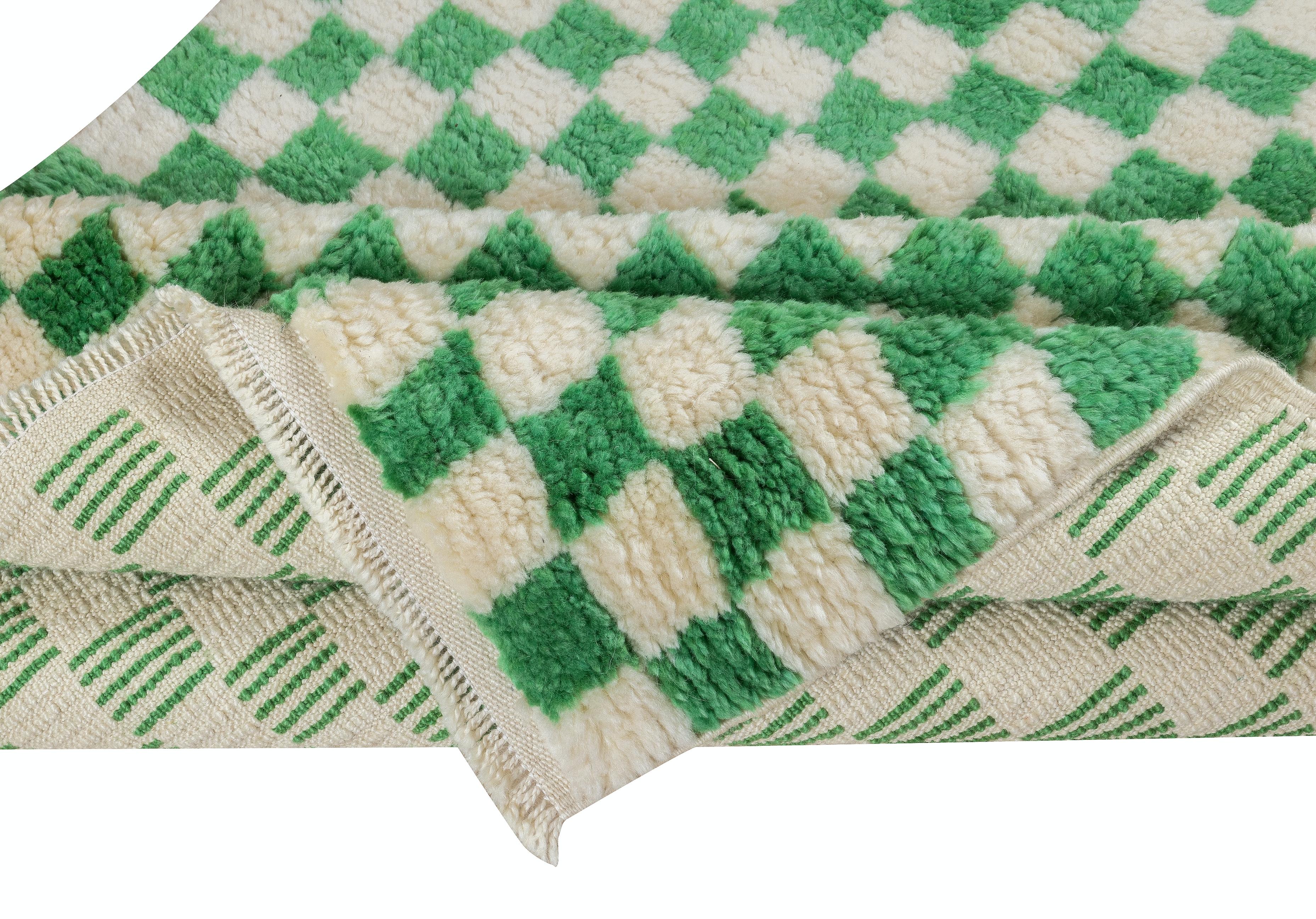Ein maßgeschneiderter, handgefertigter Tulu-Teppich aus 100% handgesponnener Wolle von feinster Qualität. Es zeichnet sich durch ein schlichtes Karomuster in Creme und leuchtendem Smaragdgrün aus.

Diese schönen Teppiche werden in unserer Werkstatt