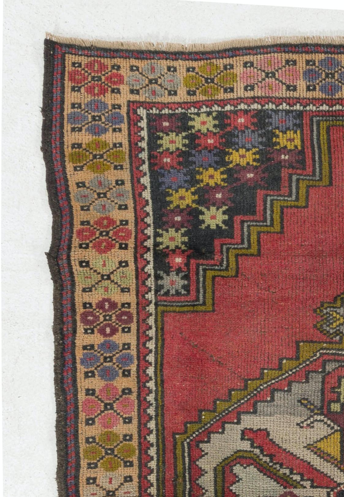 Tapis turc vintage des années 1950 finement noué à la main, présentant un motif géométrique bien dessiné avec un médaillon en son centre. Le tapis est fait de poils de laine moyens sur une base de laine. Il est lourd et repose à plat sur le sol, en