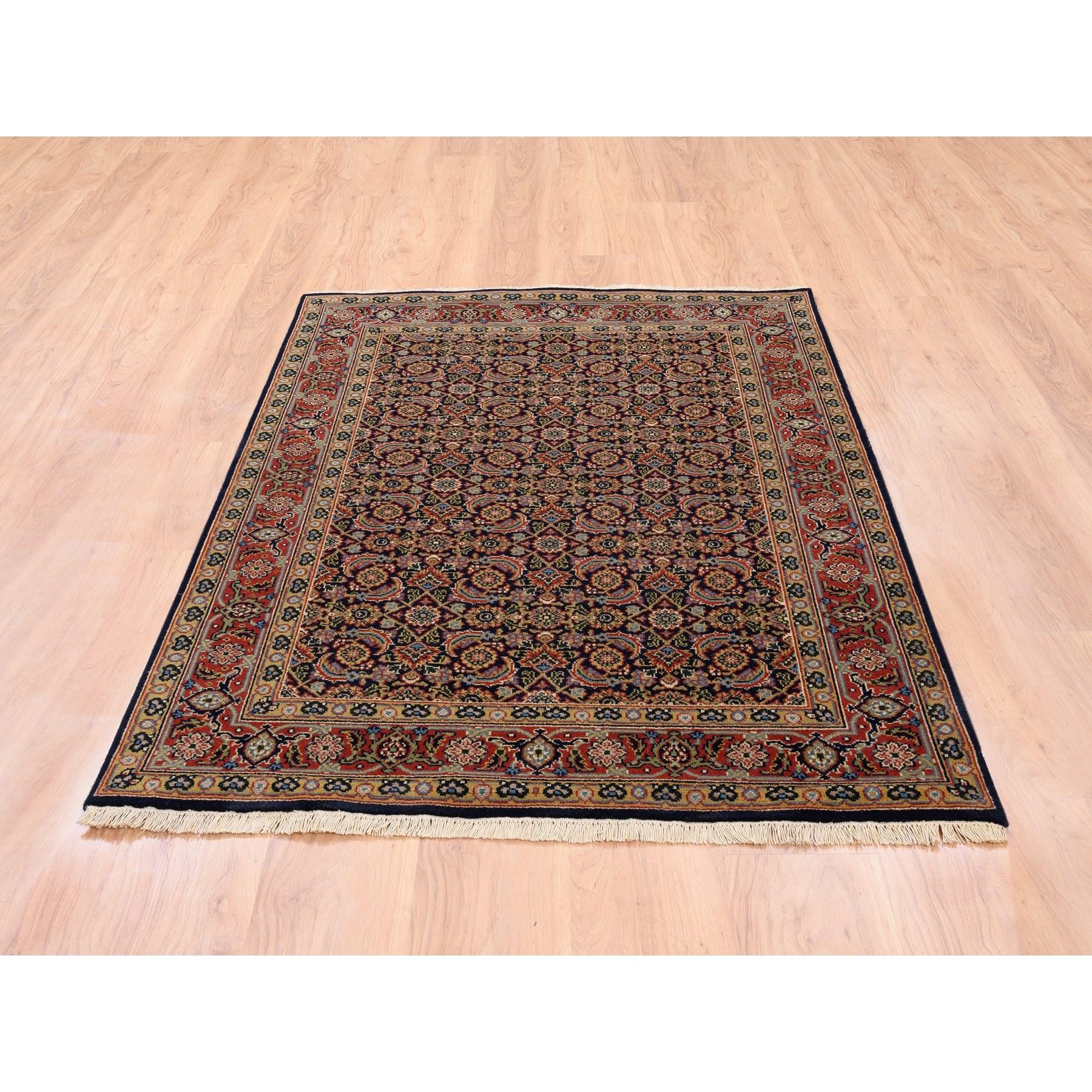 Il s'agit d'un véritable tapis d'Orient en laine filée à la main, noué à la main en noir d'encre sur fond de poisson d'Herat. Il a été noué pendant des mois et des mois selon les techniques séculaires du tissage persan par des artisans