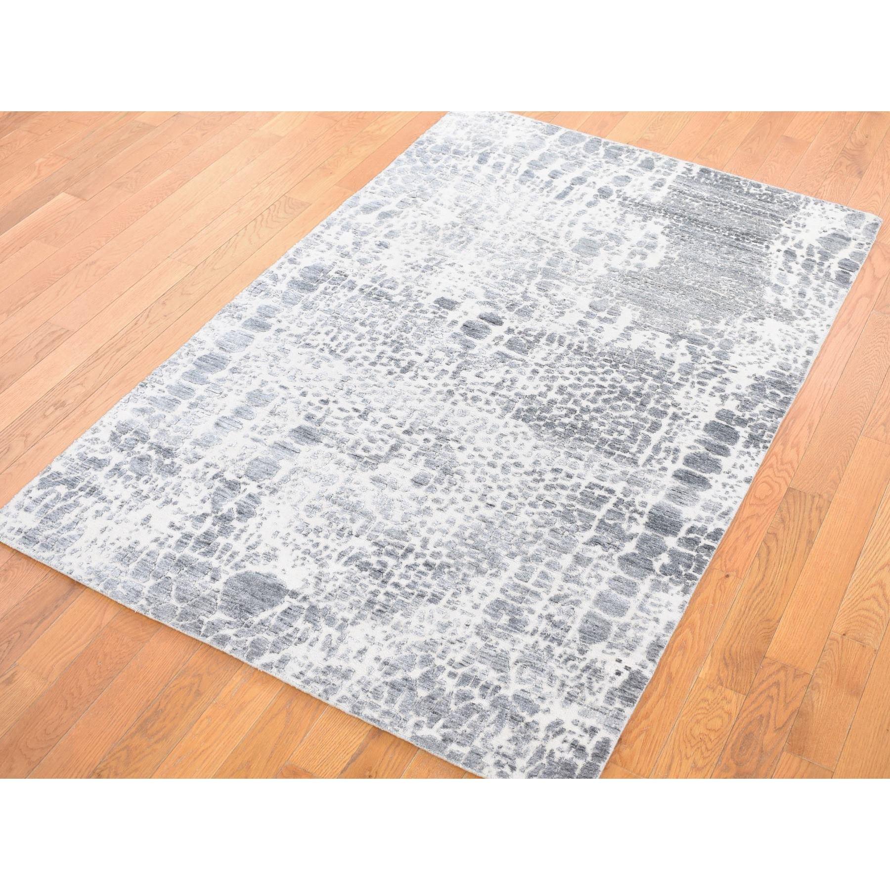 Se trata de una auténtica alfombra oriental de marfil, de diseño moderno, anudada a mano, tono sobre tono, de seda vegetal y lana texturizada. Ha sido anudada durante meses y meses con técnicas artesanales de tejido centenarias por expertos