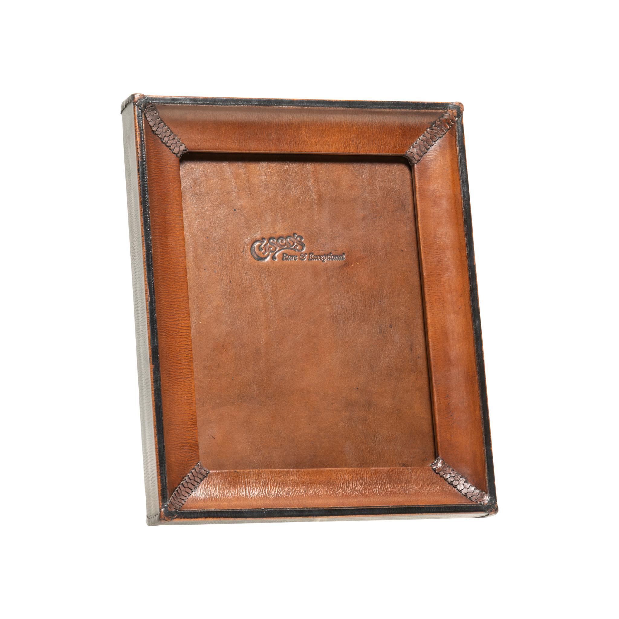 4x6 medium brown and black leather tabletop picture frame. Cisco's premium leather picture frames add the perfect accent to any home or office. Each frame is skillfully crafted by artisan saddle makers using genuine cowhide. Color: Dark brown with