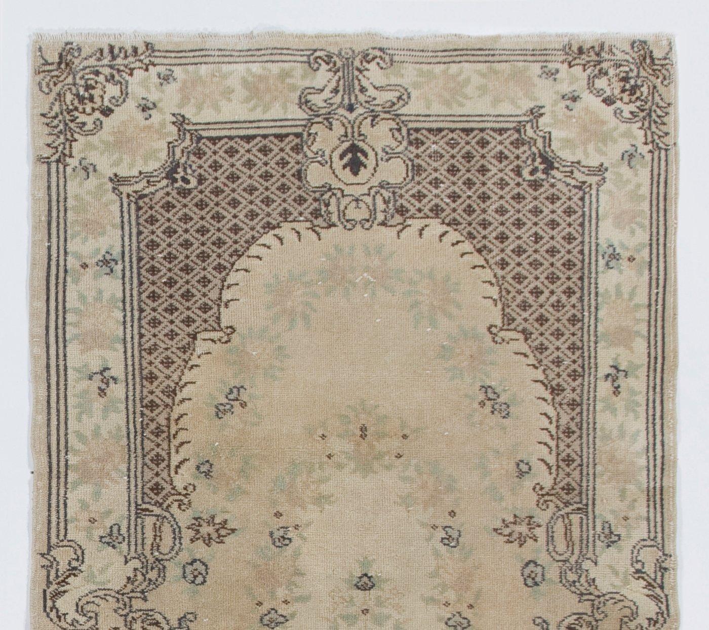 A French-Aubusson inspired vintage hand-knotted Turkish rug made in the 1960s with a design of romantic cabbage roses decorating a field in stone color framed by a large, ornamental frame in brown featuring latticed quatrefoil motifs and dramatic