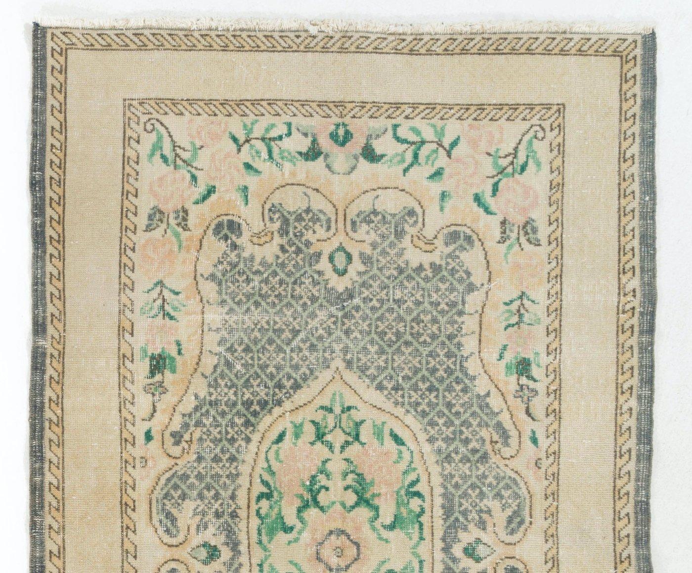 Vintage Turkish area rug with a French-Aubusson inspired romantic design of a central floral cartouche in pink and emerald green and corner pieces decorated with large pink roses against a dark indigo field with all-over honeycomb motifs that also