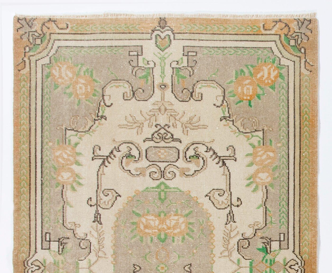 Un tapis turc vintage finement noué à la main dans les années 1960, présentant un motif floral romantique inspiré de l'Aubusson français, dans des tons ivoire, gris taupe clair, orange délavé et vert fougère.

Le tapis a des poils de laine