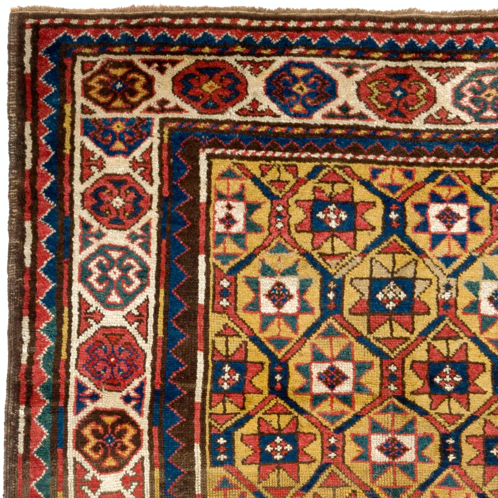 A gorgeous antique Kazak rug from the late 19th century with a sought-after goldenrod yellow field, featuring a pattern of all-over latticed pinwheels, surrounded by a large inner border filled with ram’s horns with inner and outer guard strips