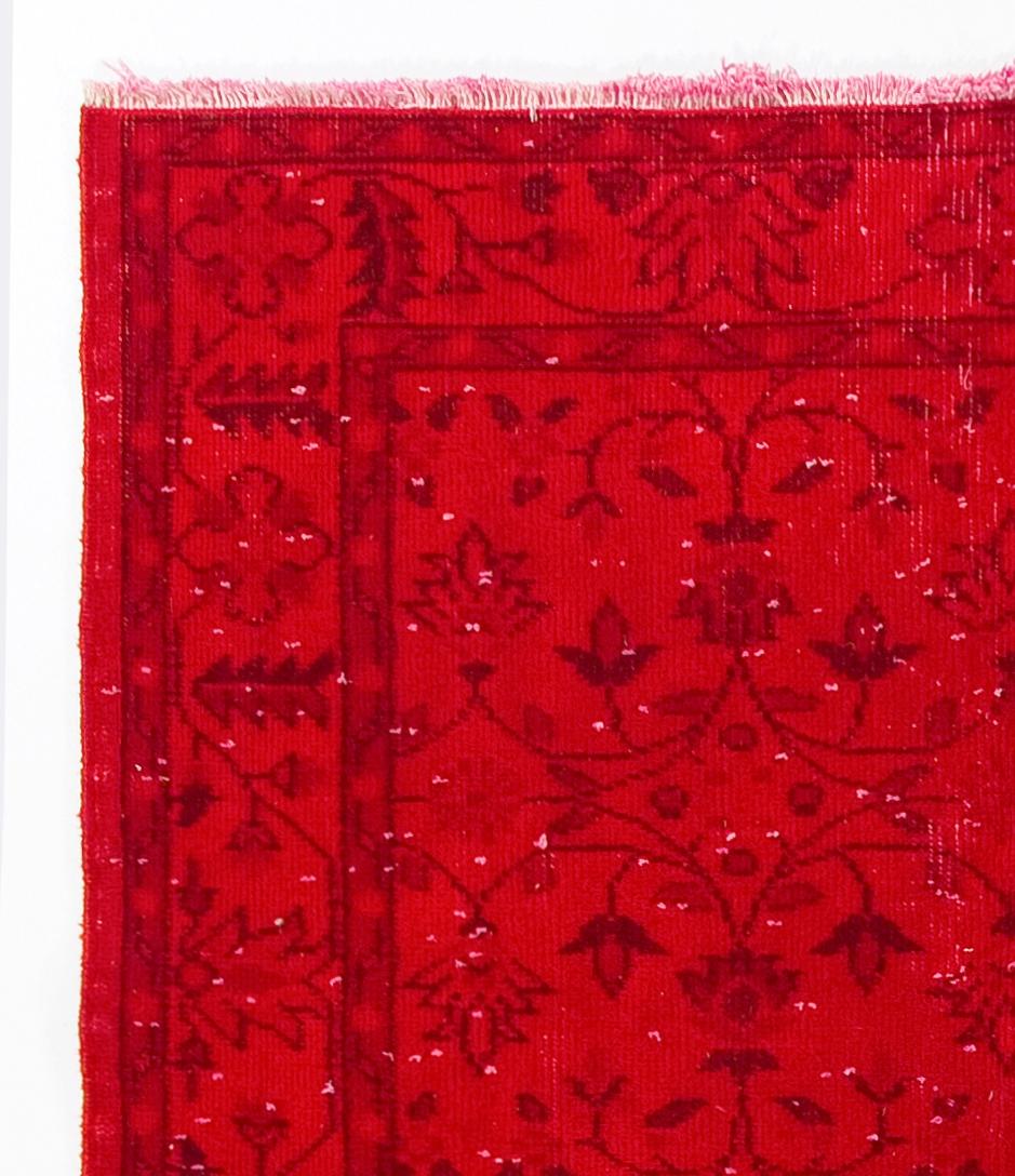 A vintage Turkish accent rug with an all-over stylized floral design over-dyed in red, great for bringing a pop of color to your interiors.

The rug is finely hand-knotted with distressed low wool pile on cotton foundation, in good condition with no