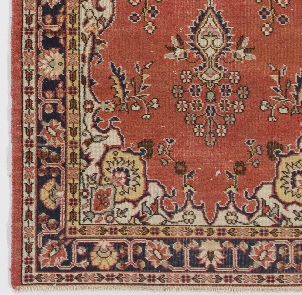 One-of-a-kind vintage and hand-knotted Turkish Oushak rug featuring a central medallion in indigo against a madder red field decorated with elegant floral vases and vines, arabesque corner pieces in ivory and borders in indigo filled with stylized