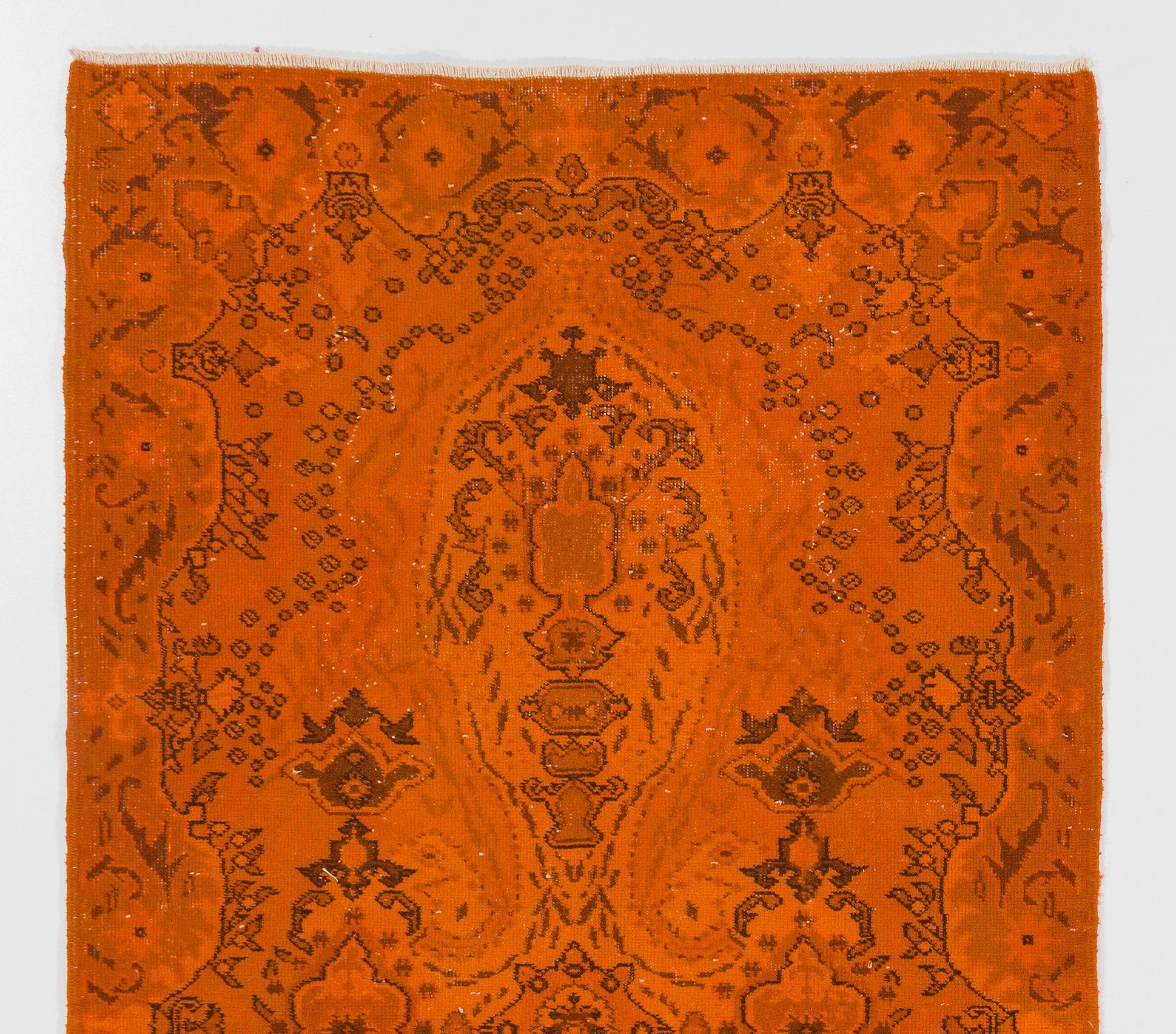 Un tappeto d'accento turco vintage tinto in arancione con un disegno geometrico floreale, ideale per dare un tocco di colore agli interni moderni. 

È finemente annodato a mano con un basso pelo di lana su una base di cotone, pulito
