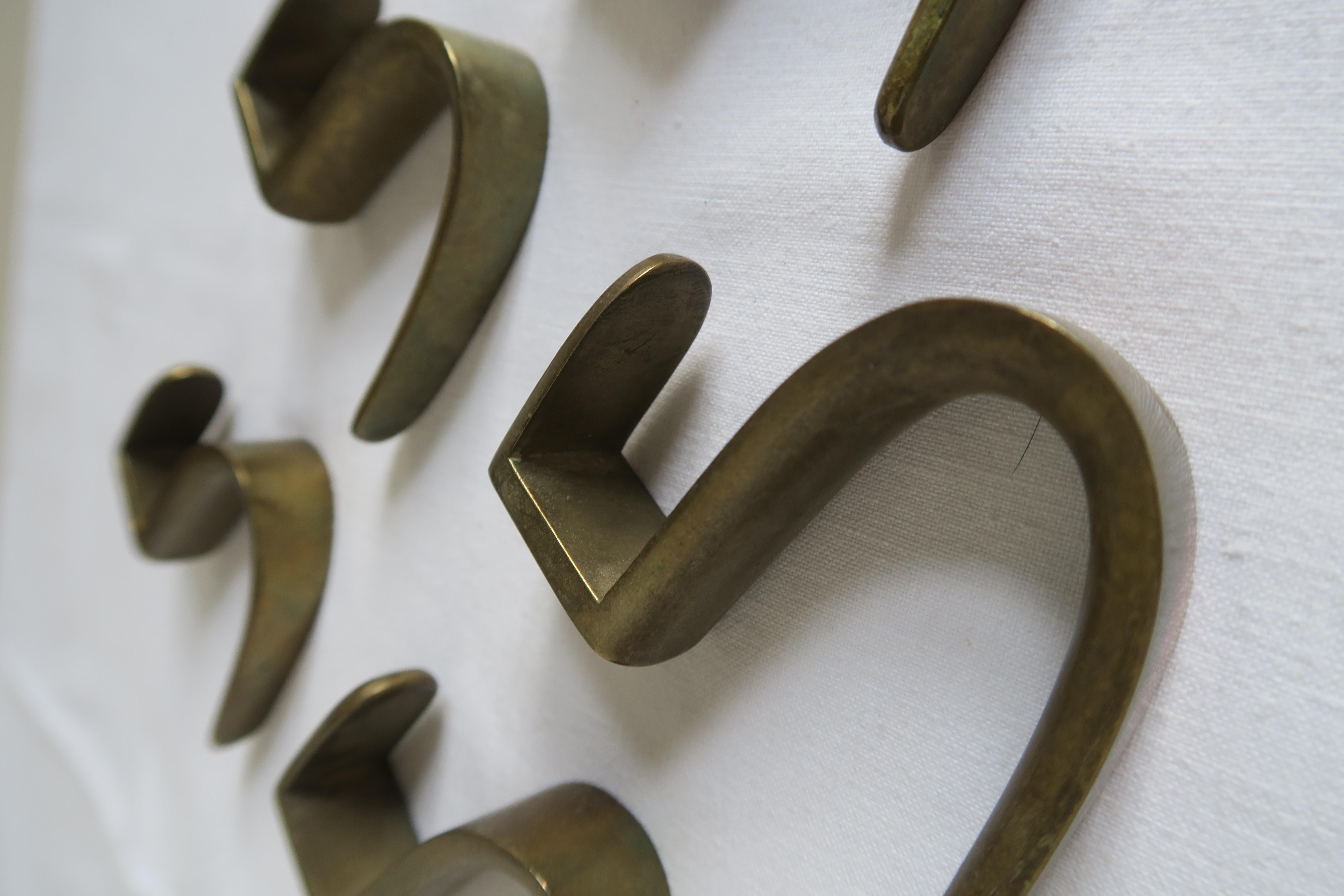 On offer are 5 massive brass coat hooks. They were designed by Carl auböck in the 1950s and produced manually by his infamous Austrian Werkstätte.
Their shape is beautifully sloped and all the edges are rounded. Time has given them a unique