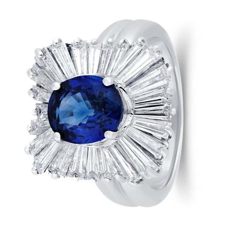 This exquisite 5 Carat Diamond and Tanzanite Ring in 14K gold features a breathtaking 2.55 carat oval tanzanite, admired for its vivid violet-blue color that captures the light beautifully. Flanking the center stone are 2.43 carats of shimmering