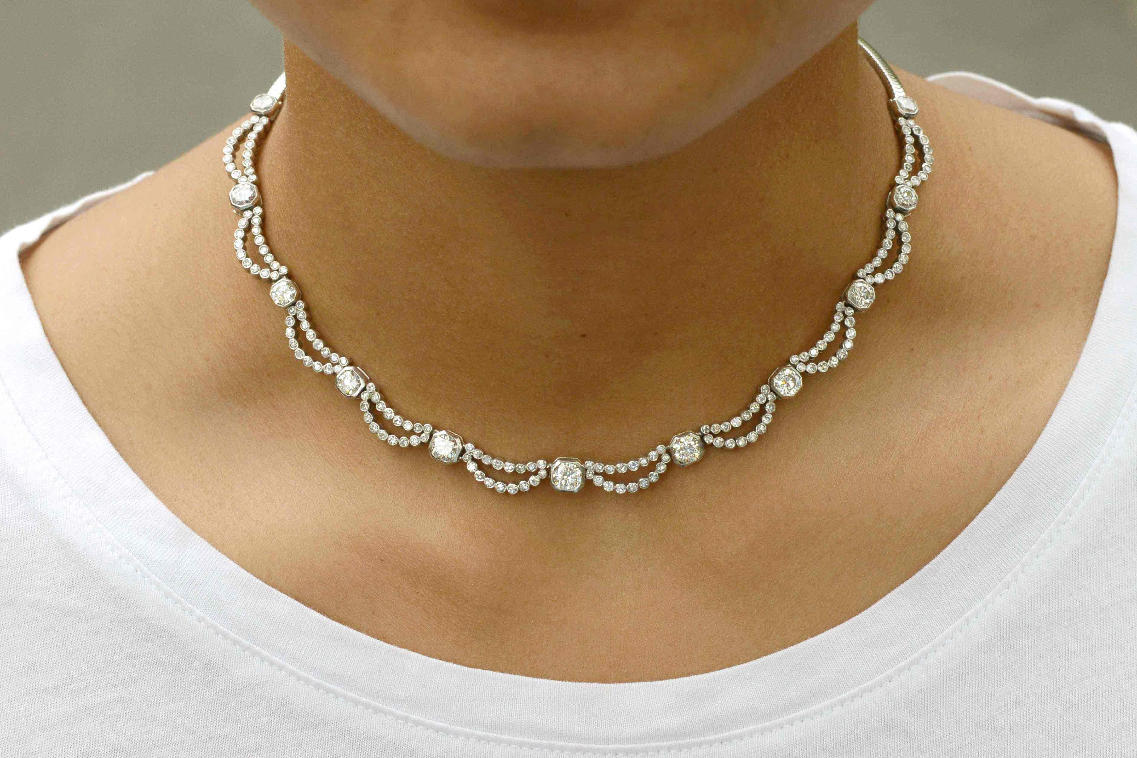 Dripping with over 5 carats of shimmering beauty, this Art Deco diamond waterfall necklace is eminently wearable. An experience of old world luxury, this vintage estate jewelry heirloom features a scalloped bib design with a silky snake chain that