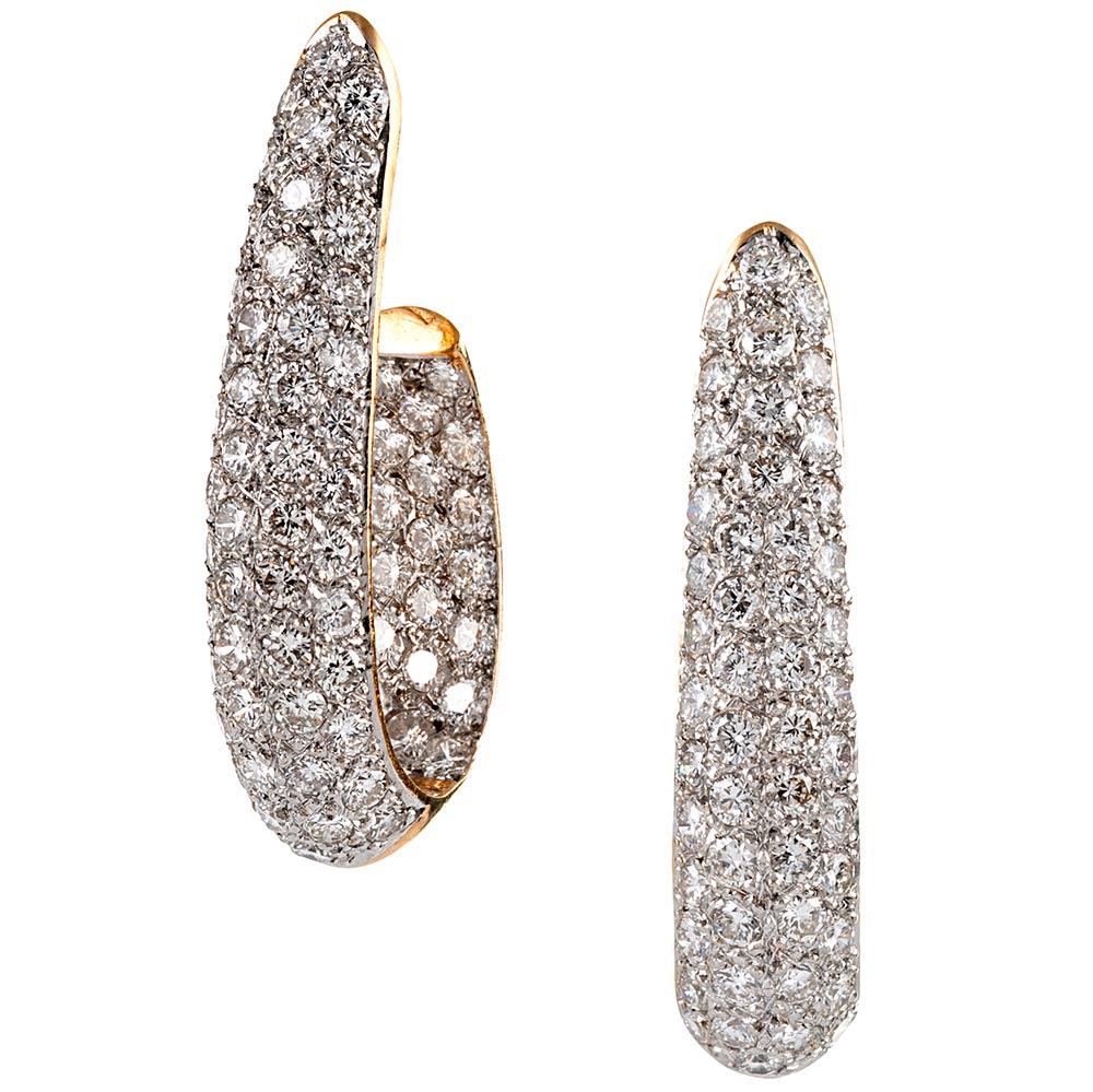 A lovely rendering of classic diamond hoops, offered in 18 karat yellow gold and set with 5 carats of brilliant white diamonds. The dramatic shape tapers slightly from bottom-to-top and the elongated style is flattering next to the face. Note the