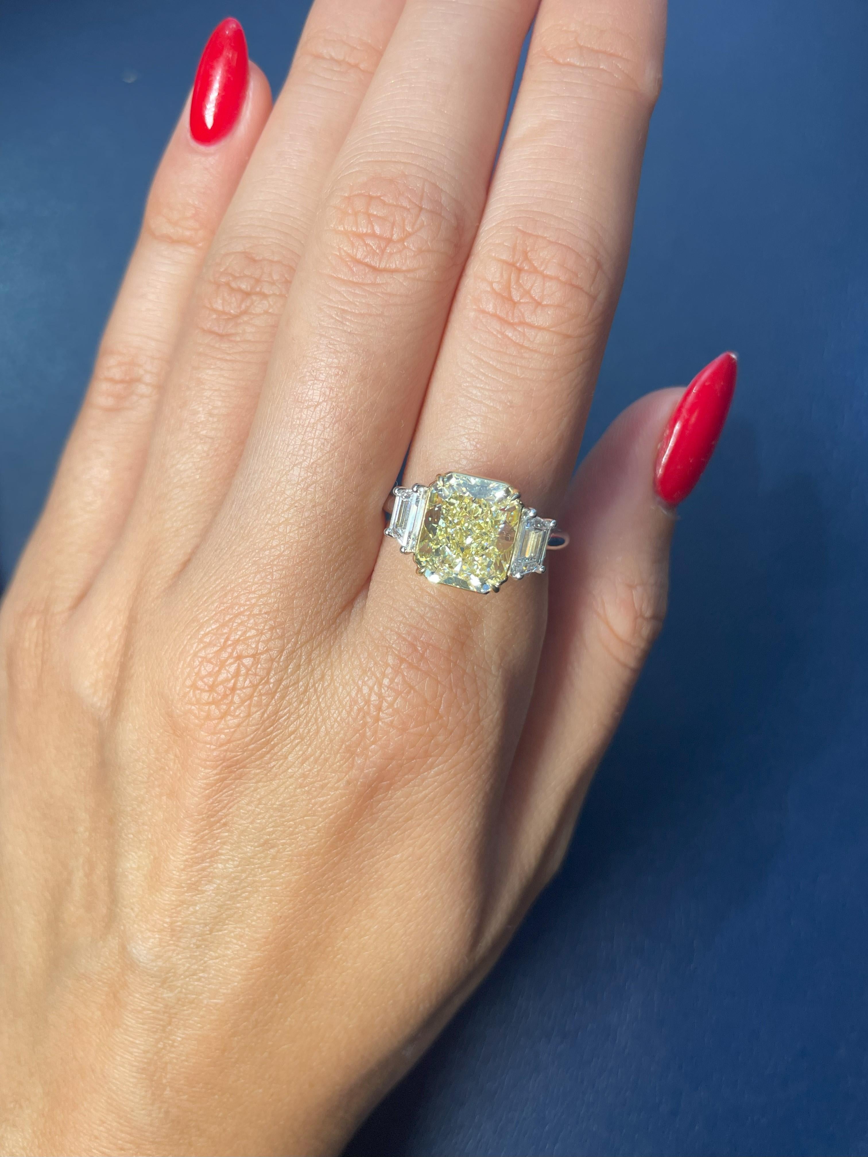Exquisite Three-Stone Engagement Ring featuring a breathtaking 5.00-carat Fancy Light Yellow, Radiant-cut diamond. This diamond has been certified by GIA as Internally Flawless, highlighting its exceptional clarity. The center diamond is elegantly