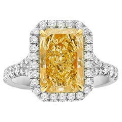 Anillo de compromiso con halo de diamantes de corte radiante alargado amarillo claro de 5 quilates