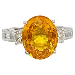 Anillo de zafiro oval naranja de 5 quilates y diamante baguette de media luna en 18 quilates