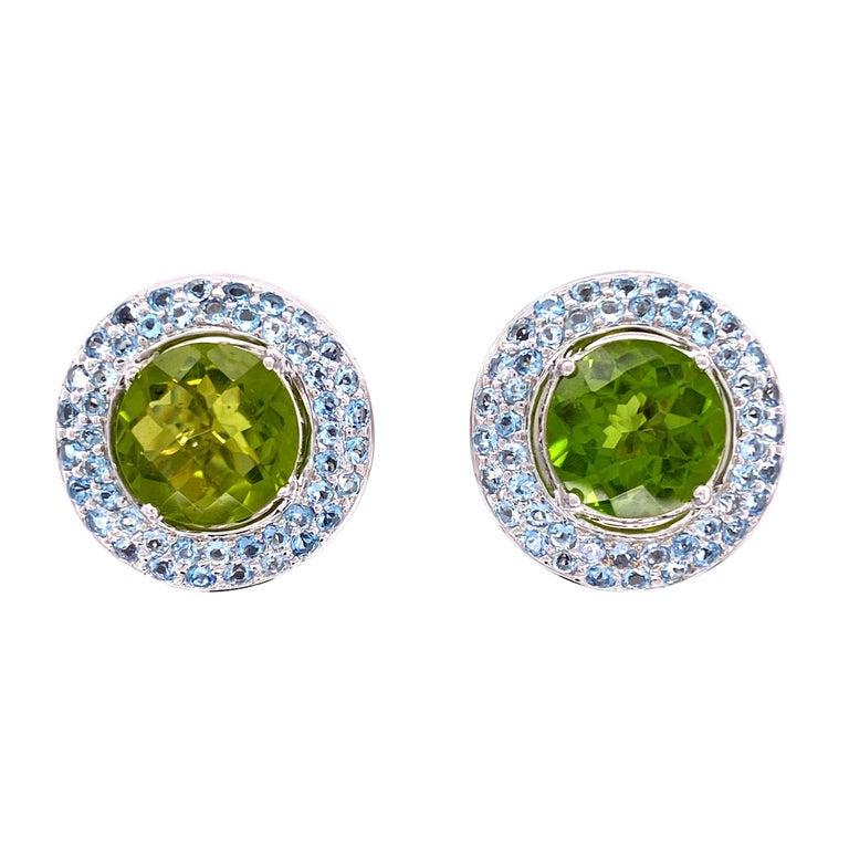 Simply Beautiful! Classic and finely detailed Designer Earrings securely set with two round checkerboard cut natural Peridot stones weighing approx. 5.00 total carat weight and are surrounded by two rows of pave Aquamarine Gemstones. Hand crafted 18