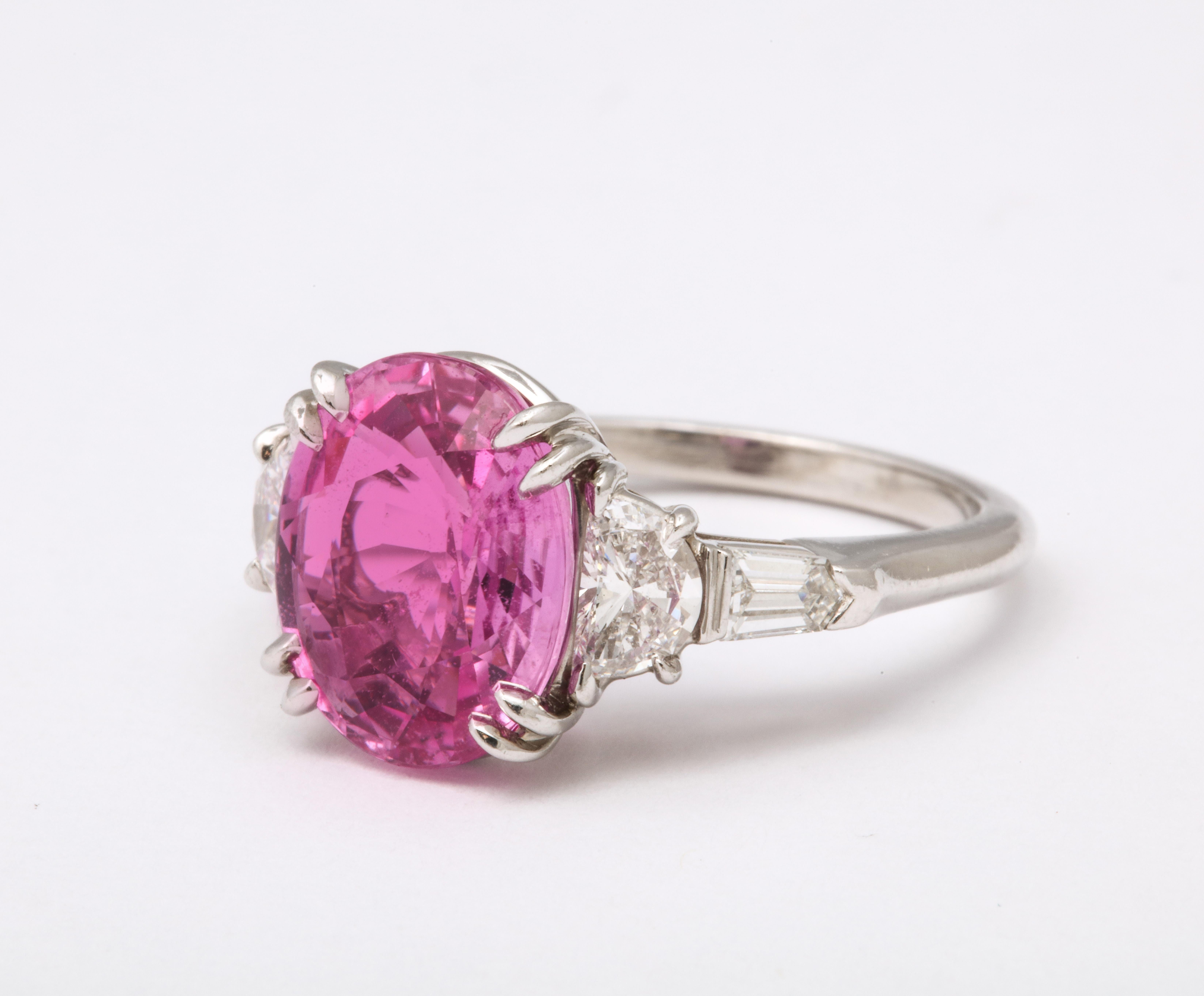 
Certified 5.15 carat oval Pink Sapphire 

.88 carats of colorless white trapezoid and baguette cut diamonds

Set in platinum

Currently a size 6.5, this ring can easily be resized to any finger size.

The sapphire is certified by Christian Dunaigre