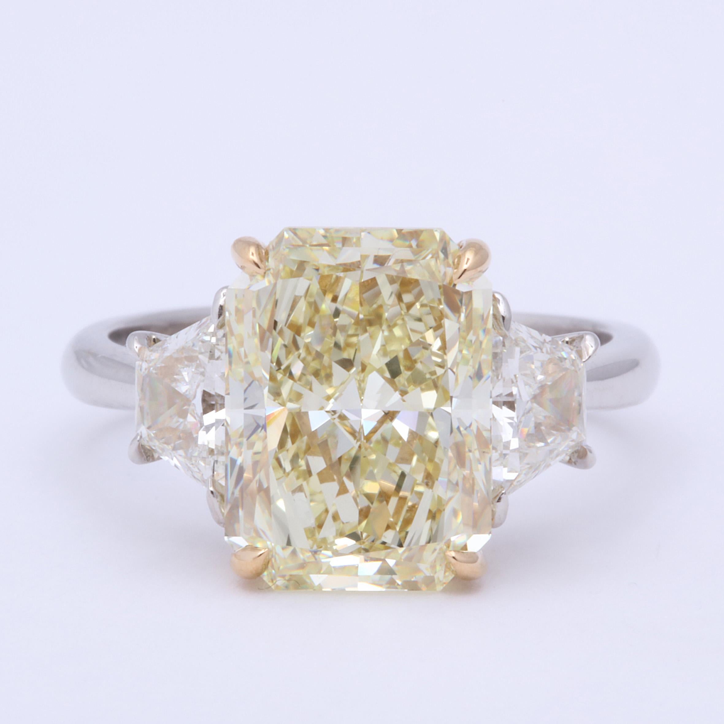 
A beautiful elongated rectangular radiant yellow diamond ring!

5.27 carat center GIA Certified Fancy Light Yellow, VS1 clarity. 

Set with .89 carats of white side diamonds. Set in platinum and 18k yellow gold.

Currently a size 6 but can be