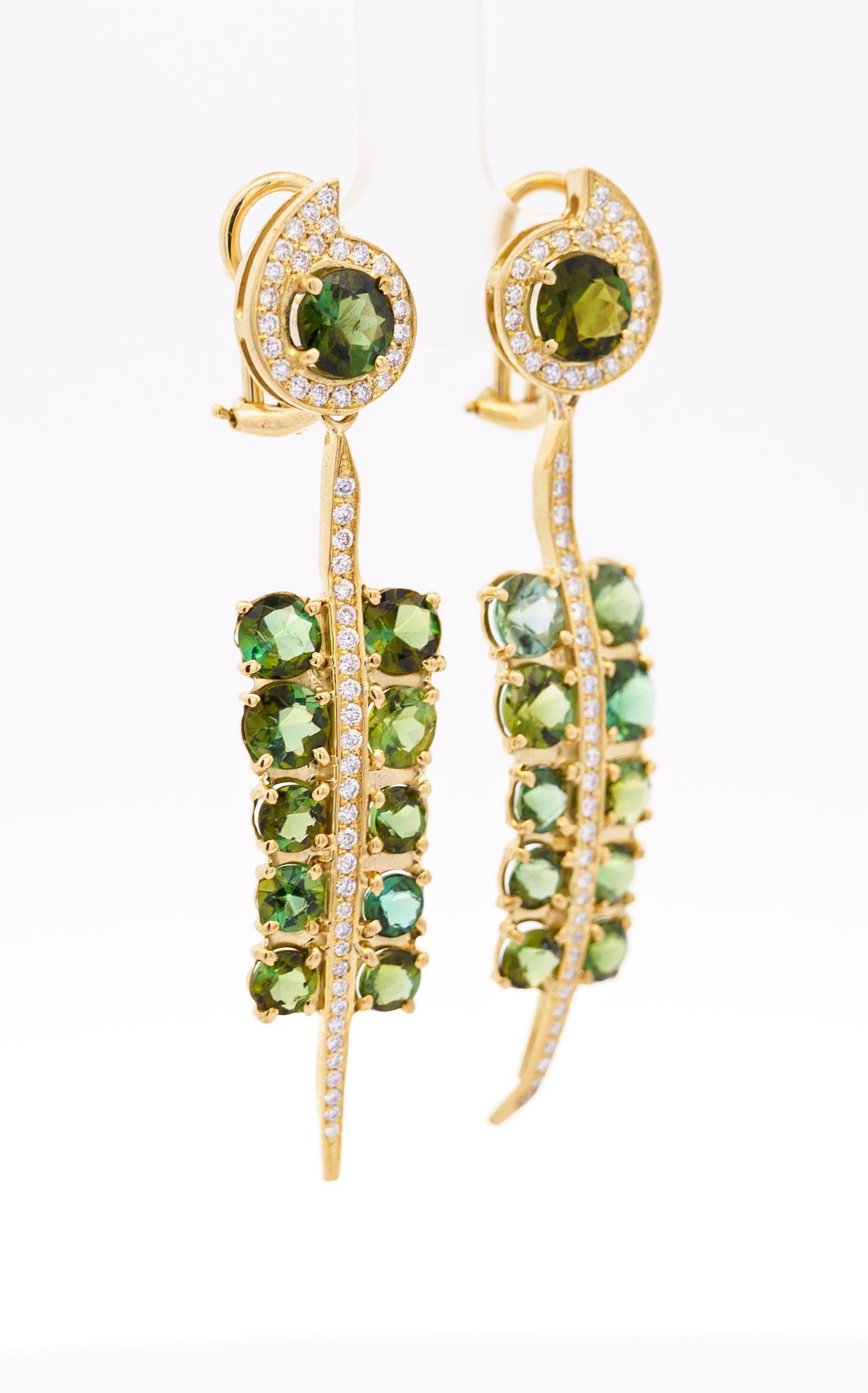 18k yellow gold dangle drop earrings, featuring a stunning 5 carats of oval round cut green tourmaline. The tourmaline gemstones are framed by white round diamonds, set in a  combination of prong and bezel settings. The tourmalines dangle from the