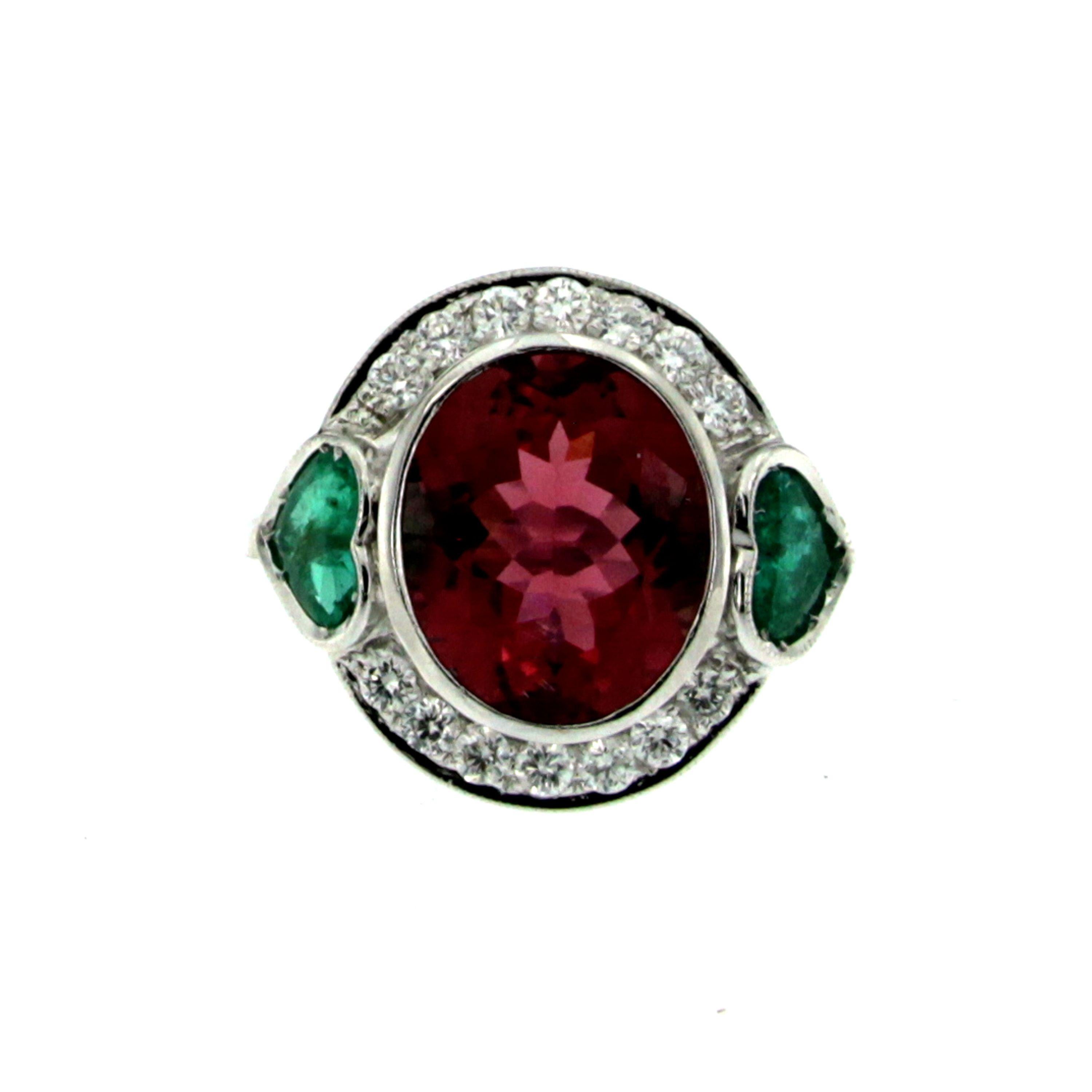 This beautiful and bright cocktail ring is set in the center with one large natural Oval Mixed Cut Rubellite Tourmaline with a vibrant and rich color, weigh 4,80 ct. flanked by two heart cut columbian Emeralds with an approx. total weight of 1 ct