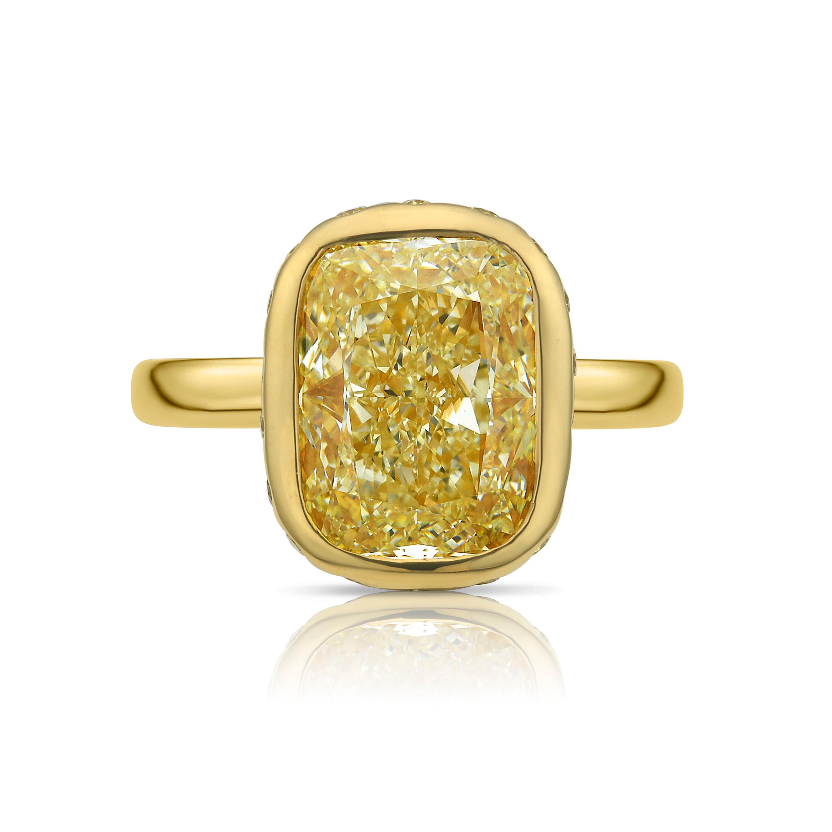 This standout ring features a 5 carat fancy yellow diamond set in a clean bezel, surrounded by a soft mosaic of yellow diamond pavé that adds dimension and sparkle. The warm tones of the yellow diamonds are beautifully complemented by the 18k yellow