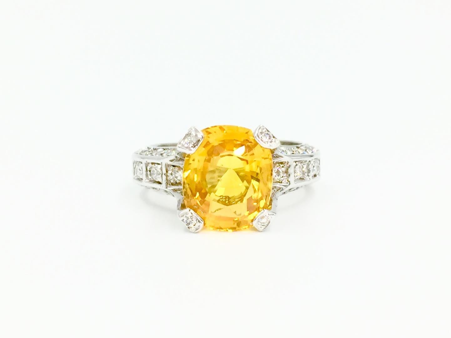 Beautiful vivid medium tone five carat cushion cut yellow sapphire is set perfectly in this Leslie Greene 18 karat diamond mounting. Sapphire is very clean with few visible natural inclusions. White gold setting features 1.16 carats of diamonds,