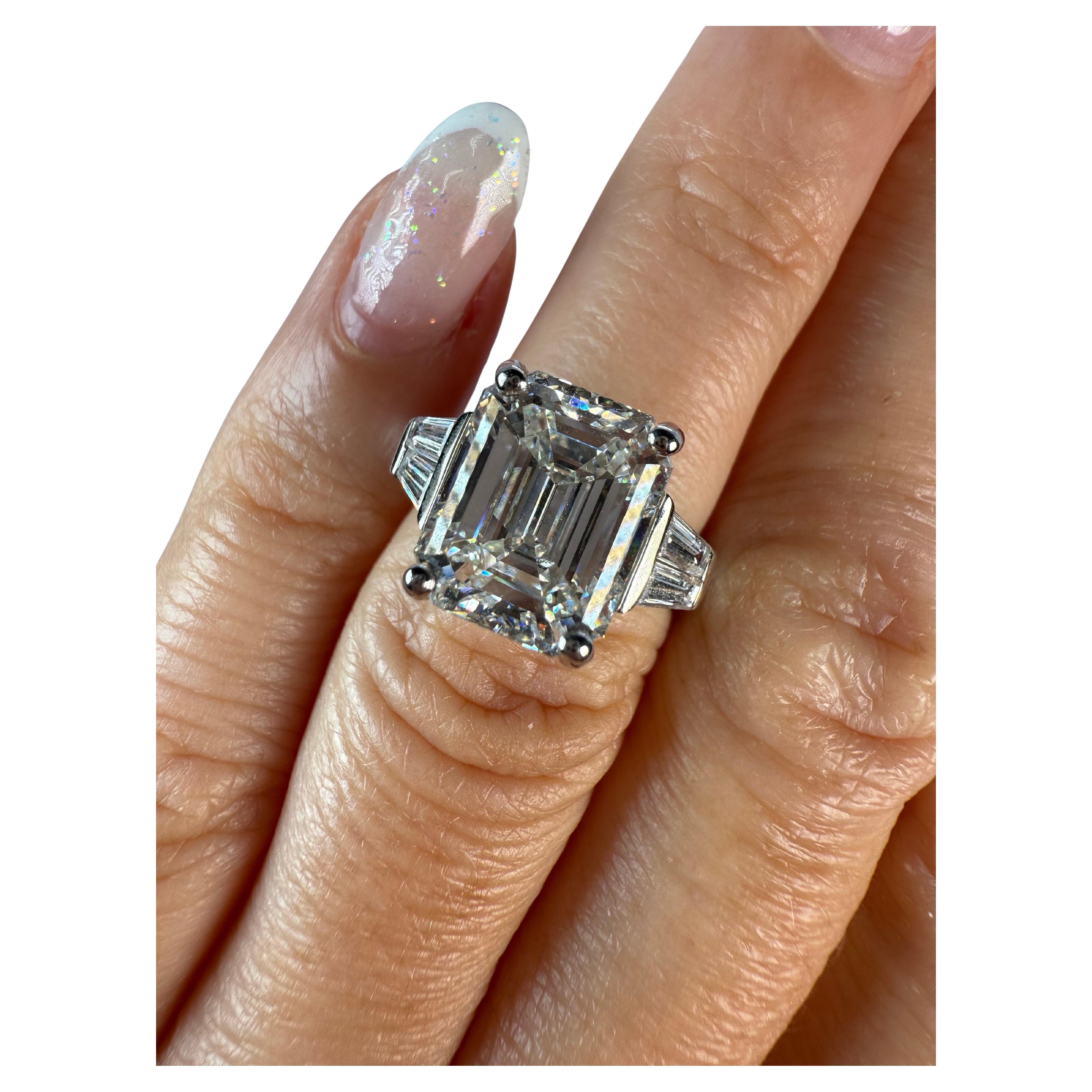 Bague en diamant de 5 carats avec une magnifique émeraude au centre accompagnée de deux trapèzes de chaque côté. La bague est faite en platine en taille 5. Can être redimensionné, s'il vous plaît se renseigner si vous voulez plus de détails. 

CE