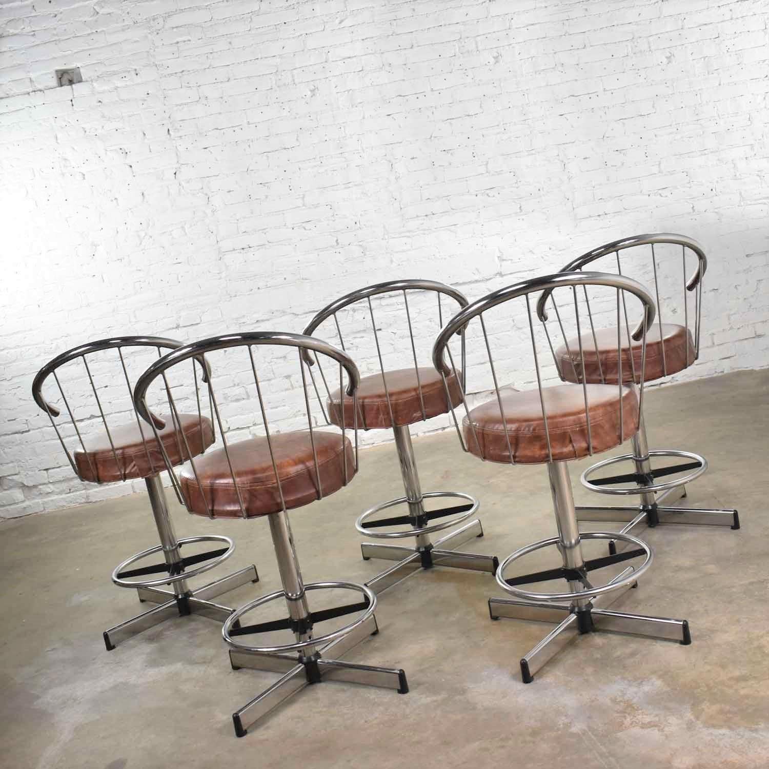 Handsome set of 5 vintage modern chrome bar stools or counter stools by Cosco with brown vinyl faux leather seats. They are in awesome vintage condition. There is some wear to the vinyl and normal signs of age to chrome. Please see photos, circa