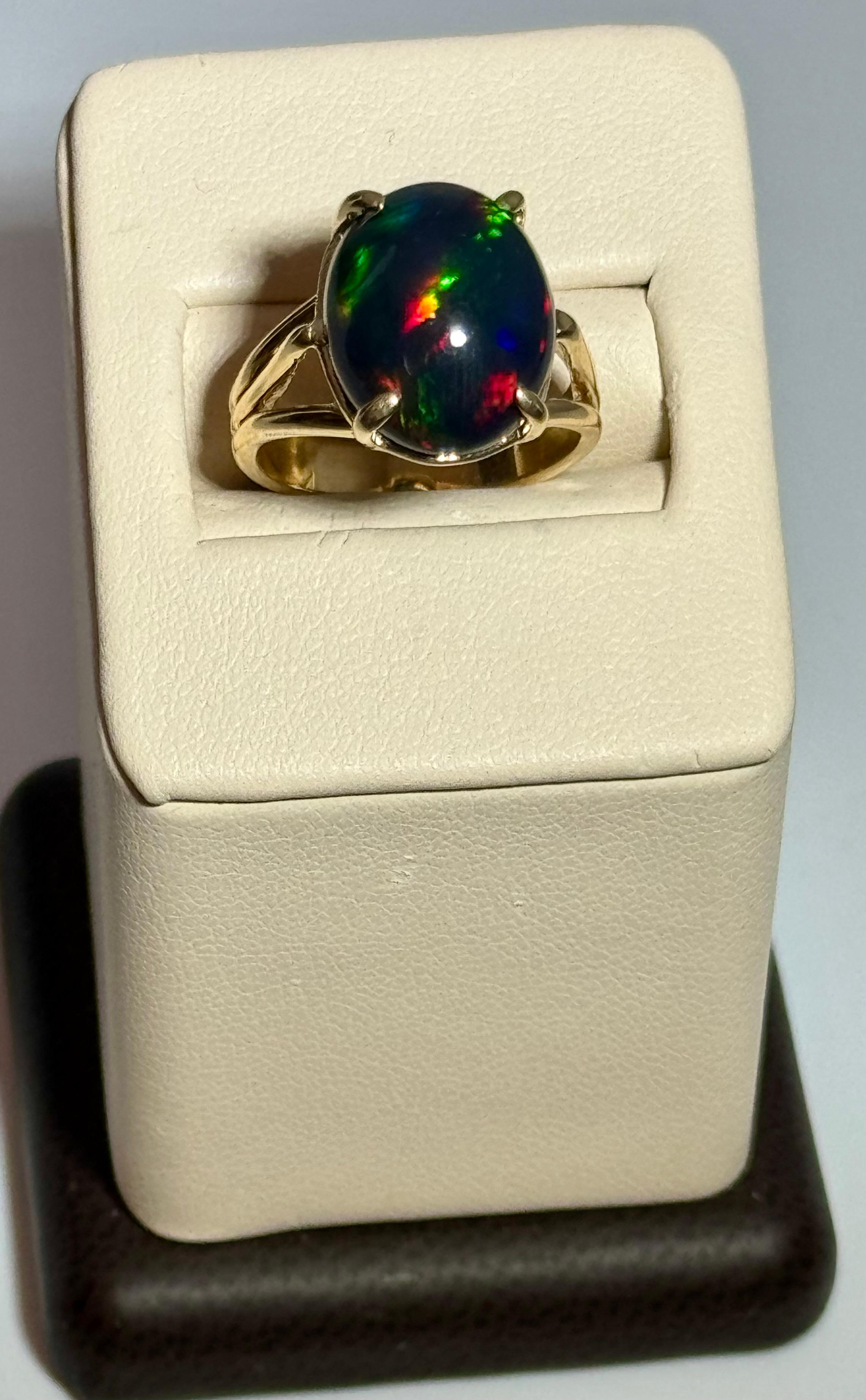 Introducing our captivating 14 Karat Yellow Gold Cocktail Ring featuring a breathtaking 5 carat oval-shaped Black Australian Opal Cabochon . This remarkable piece showcases the opal's mesmerizing shades of green and blue, radiating with a brilliant