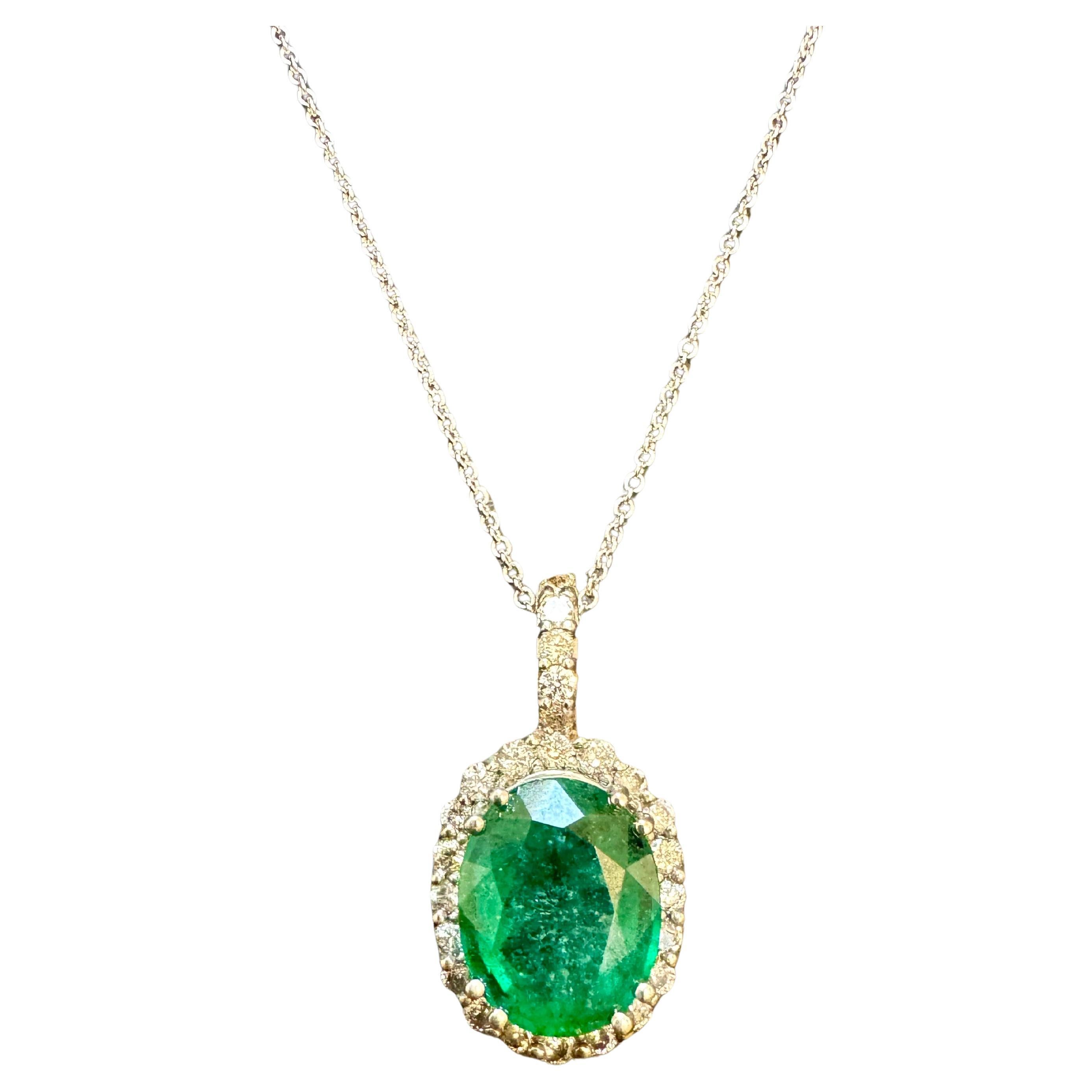 Ciondolo e collana di smeraldo di forma ovale da circa 5 carati, 14 carati, Whiting  Oro con catena
Questa semplice ma elegante collana è composta da un unico smeraldo di forma ovale circondato da diamanti rotondi a taglio brillante e da una solida