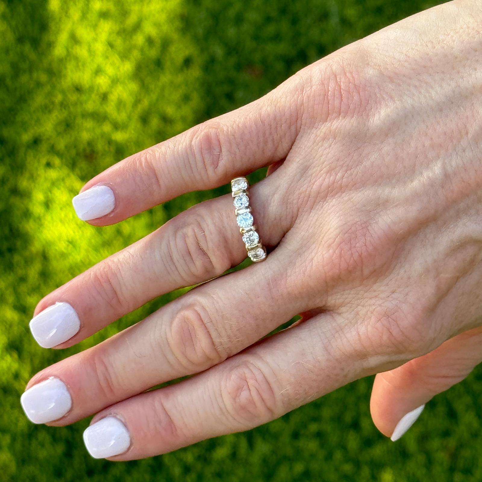 The 5 Diamond Band Ring is a classic and elegant piece of jewelry. Featuring five dazzling round brilliant cut diamonds set in a warm 14 karat yellow gold band, this ring exudes timeless sophistication and understated luxury. The diamonds weigh