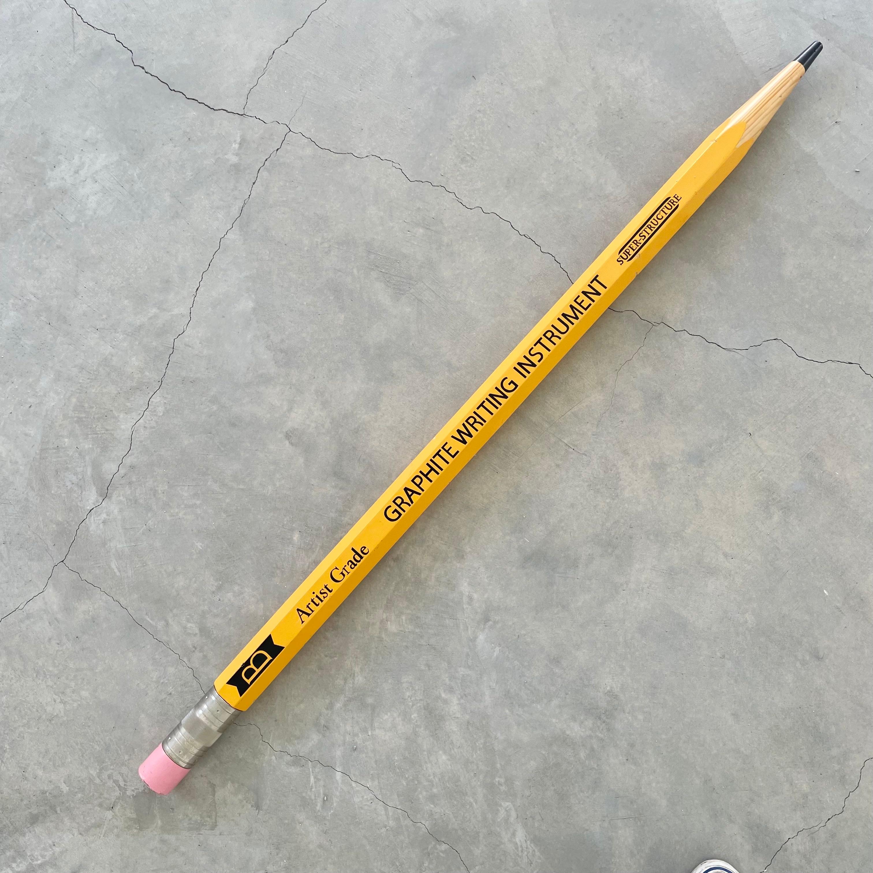 Massive vintage display pencil. Made of one solid piece of wood and a machine engraved metal ring wrapped around the end by the eraser. Size: 60