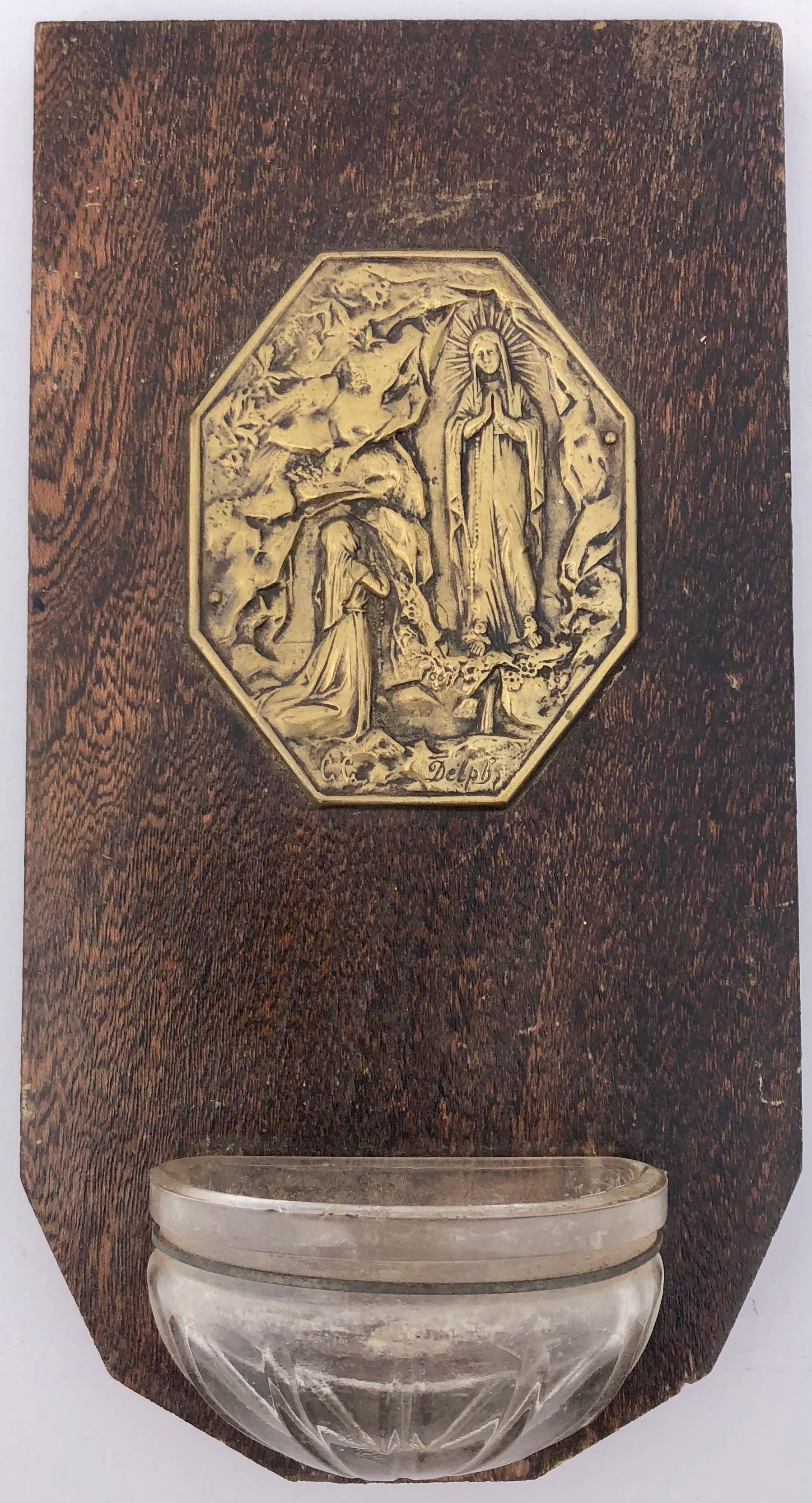 The five French Benetiers have either glass or metal holy water fonts, metal medallions and plaques mounted on wood commemorating the- Miracle of Lourdes, Jesus providing blessings, Mary in profile, St Joan of Arc and a Crucifix. All are from the