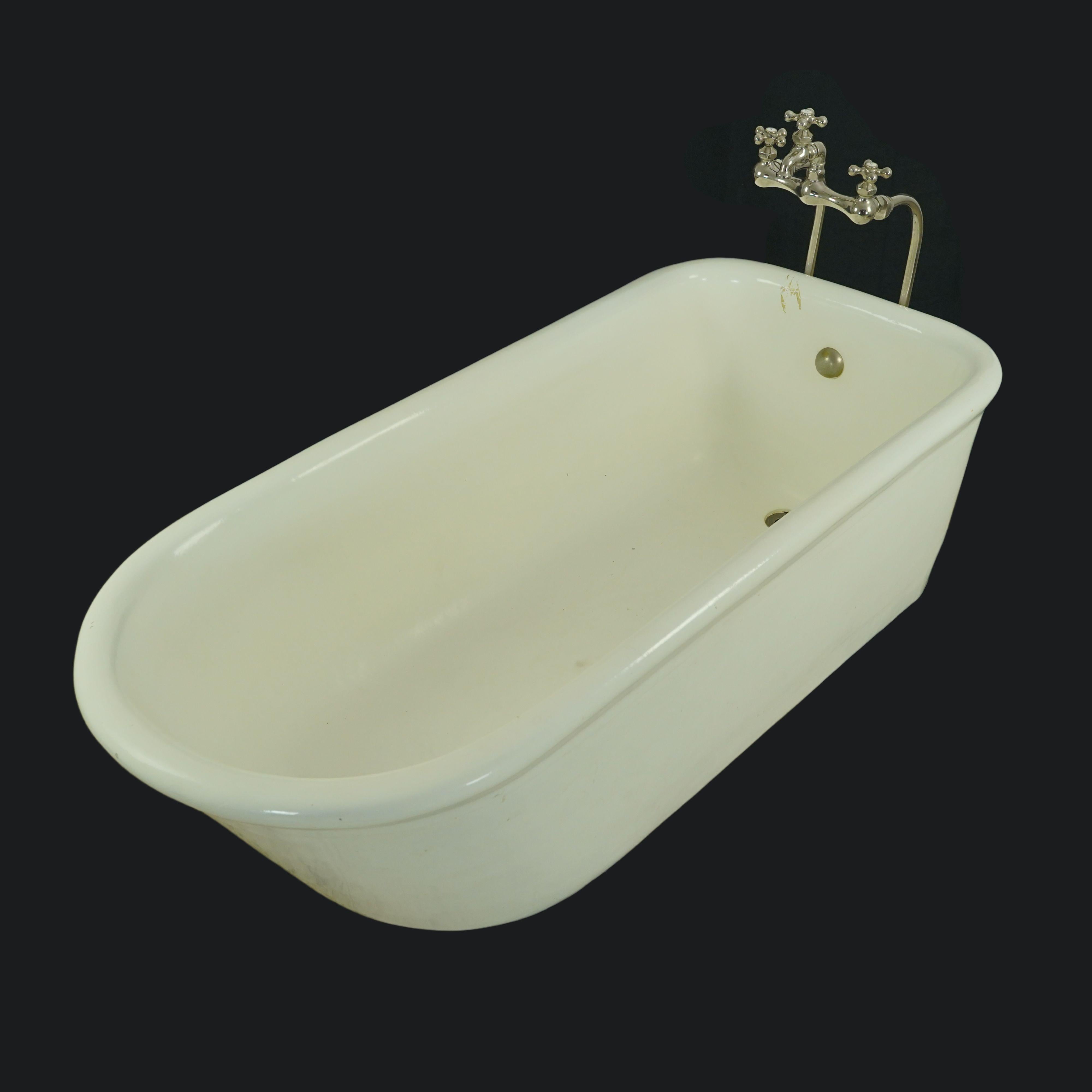 Bañera de cerámica de barro blanco con perfil cero hasta el suelo. Se incluye un grifo de fontanería de pared de níquel pulido más nuevo. La loza es propensa a encogerse, por lo que el vidriado de la cubeta presenta algunas grietas y pequeños