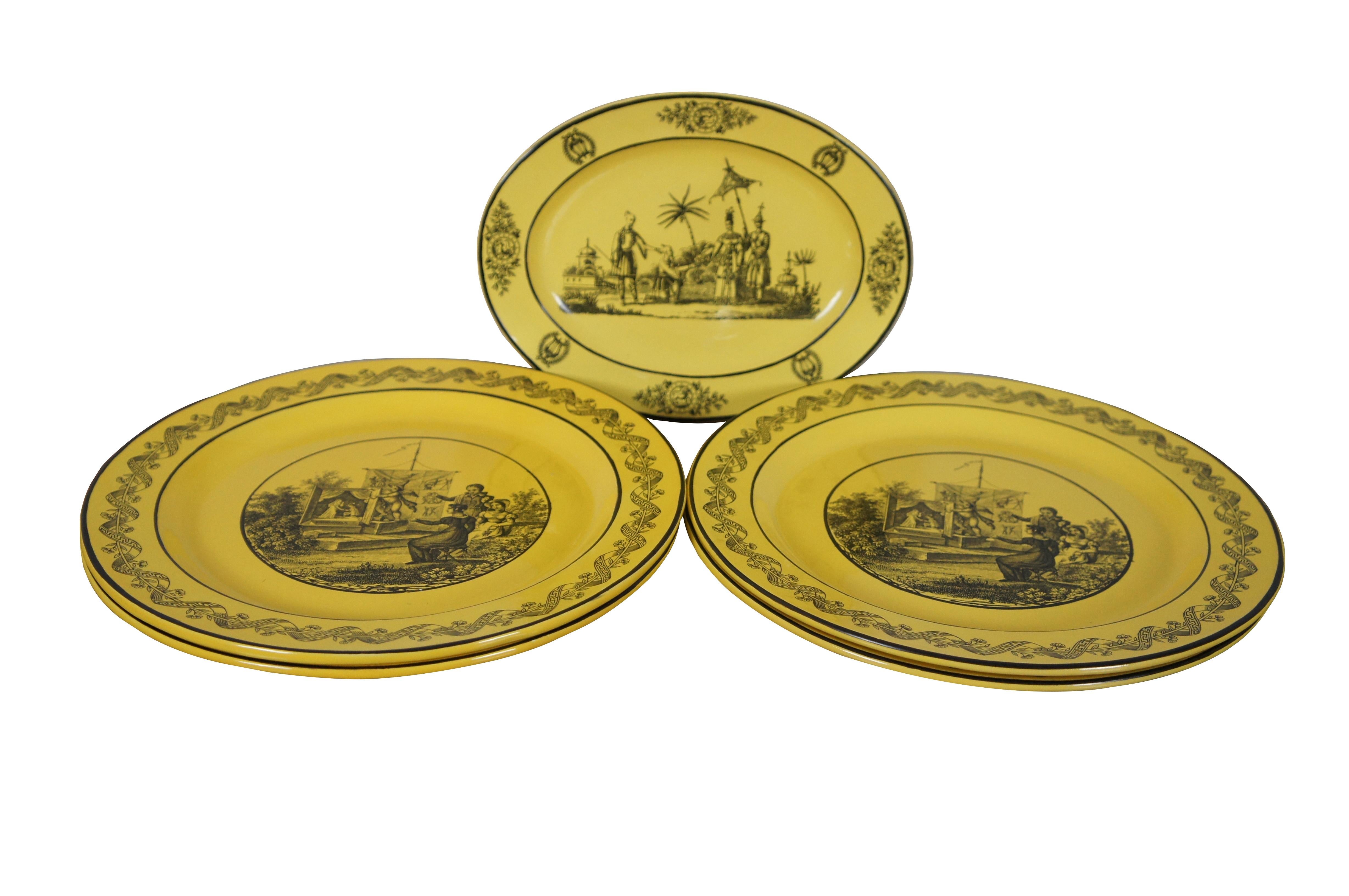 Set of four dinner plates and one oval dish in the early 19th century Criel style – mustard yellow grounds with black transferware scenes. The dinner plates show Regency era figures watching a cherub perform a puppet show in a garden. The oval dish