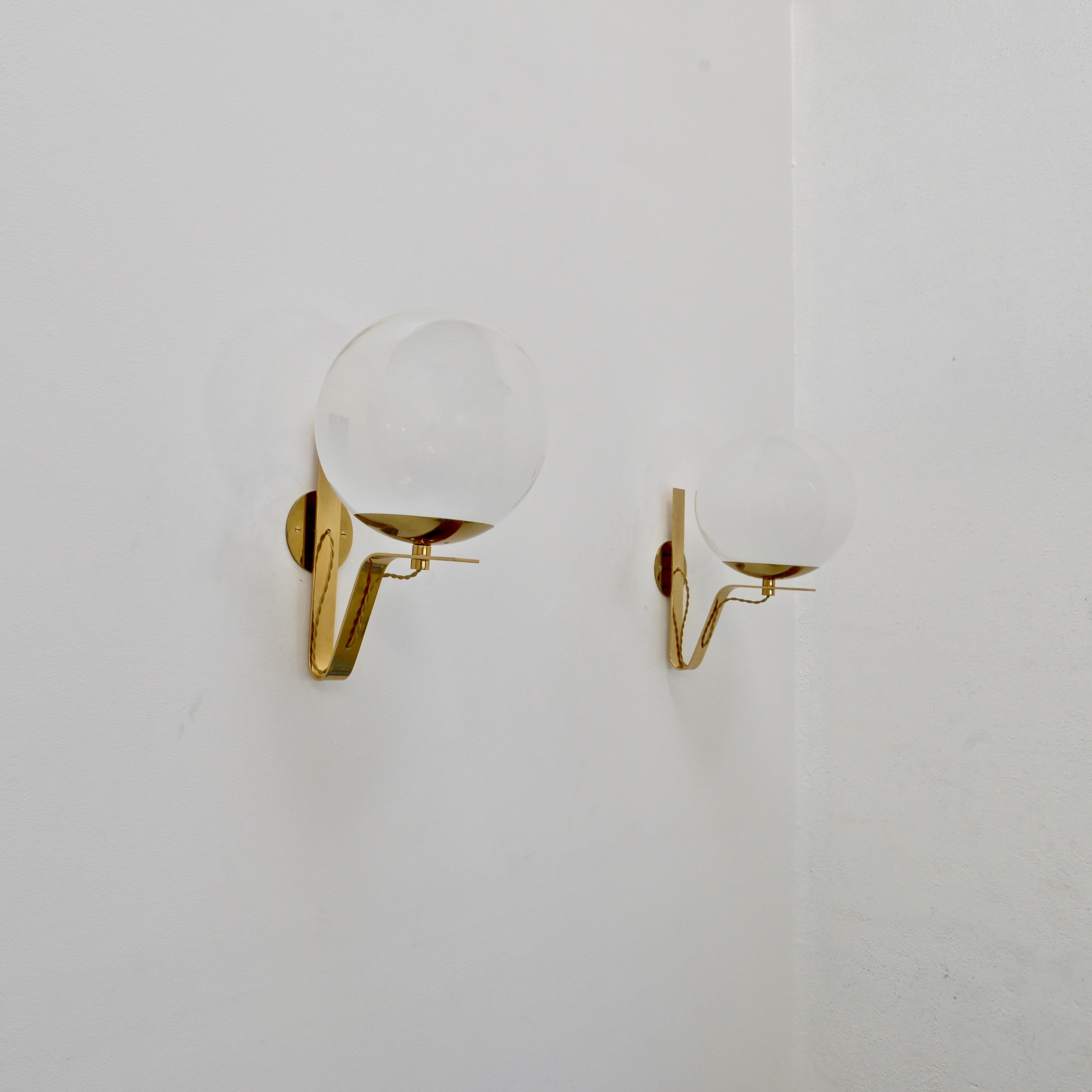 5 Elegant Mid-Century Modern 1950s glass and brass Large Globe Sconces from Italy. Patinated brass hardware finishes and blown glass shades. Single E26 medium based socket per shades. Currently wired for use in the US. 4” back plate. Light bulb