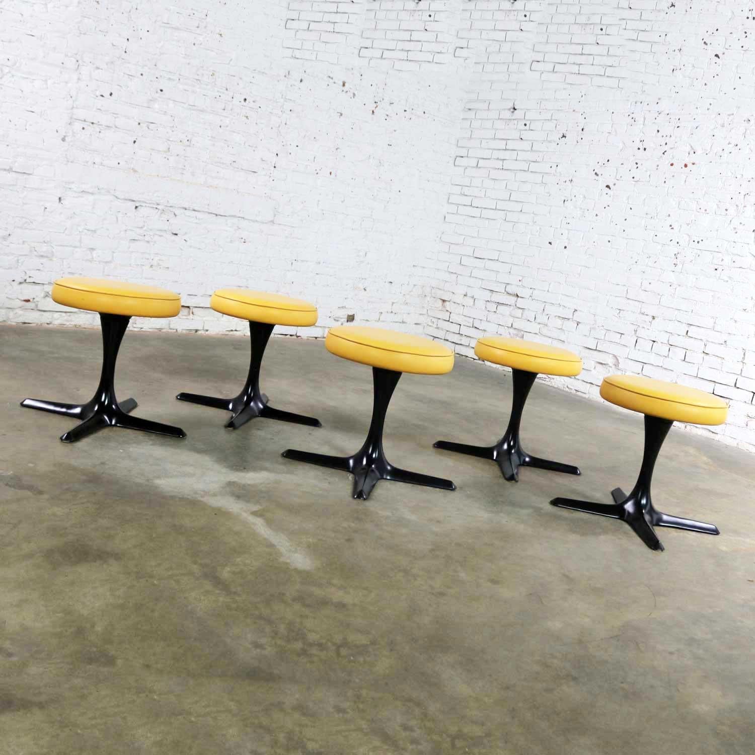 Fabulous set of 5 Mid-Century Modern tulip style swivel low stools by Burke Division for Brunswick. They have their original yellow-orange vinyl or faux leather upholstery. It may not be perfect, but it certainly is usable. We have restored the