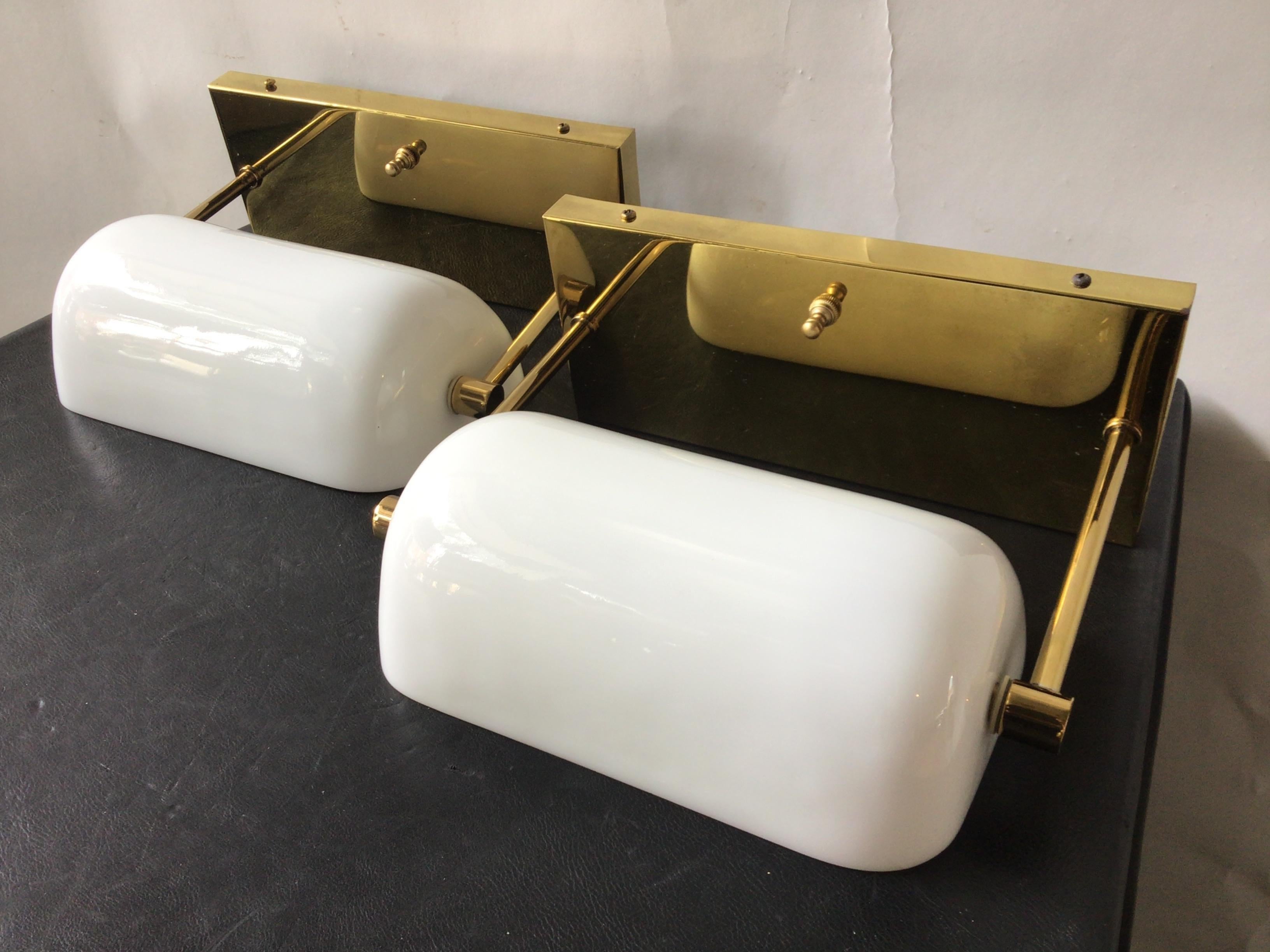 Pair of 1970s Brass and milk glass bankers lamp sconces by Nessen.
Only sold in a pair. The price for the pair is 1400. 
Must buy 2 sconces. 2 sconces are 700 each, equaling 1400.